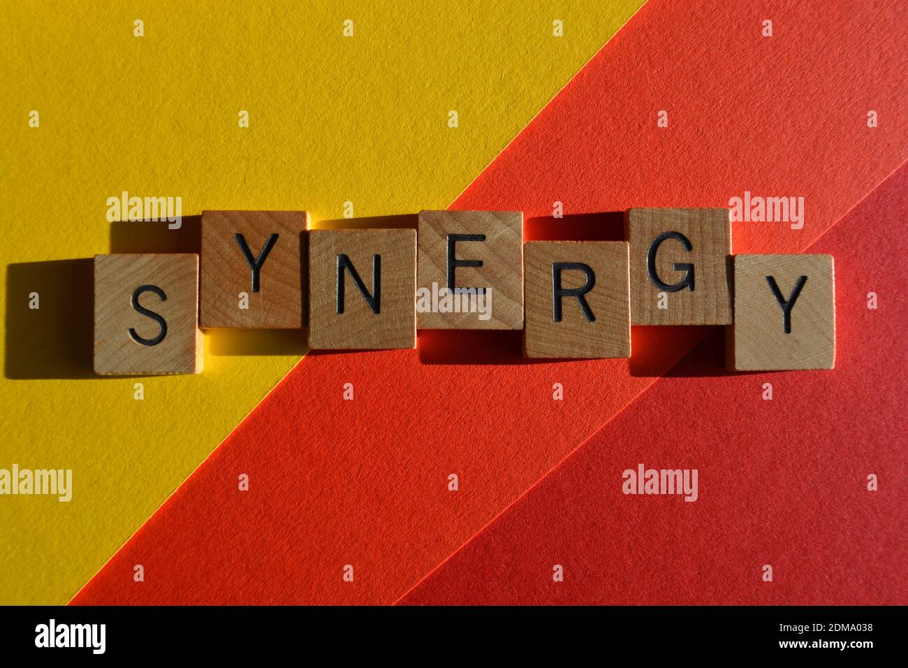 Synergie, Wort in hölzernen Buchstaben auf buntem Hintergrund isoliert Stockfoto