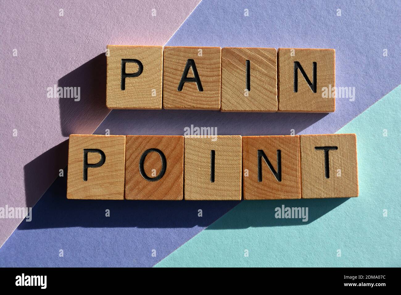 Pain Point, Buzzword Phrase in hölzernen Buchstaben auf farbigem Hintergrund isoliert Stockfoto