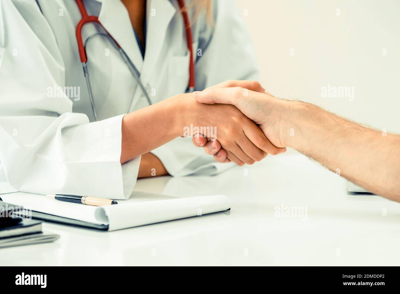 Frau Doktor tun Handshake mit männlichen Patienten im Krankenhaus Büroraum. Gesundheit und Medizin service Besetzung. Stockfoto