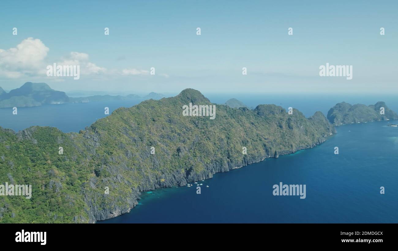 Blue Sea Bay auf den Berginseln des Visayas Archipels Luftbild. Niemand Natur Seesapfel mit tiefblauem Wasser mit türkisfarbenen Schatten. Grüner Tropenwald und Pflanzen an der Felsküste der El Nido Inseln Stockfoto