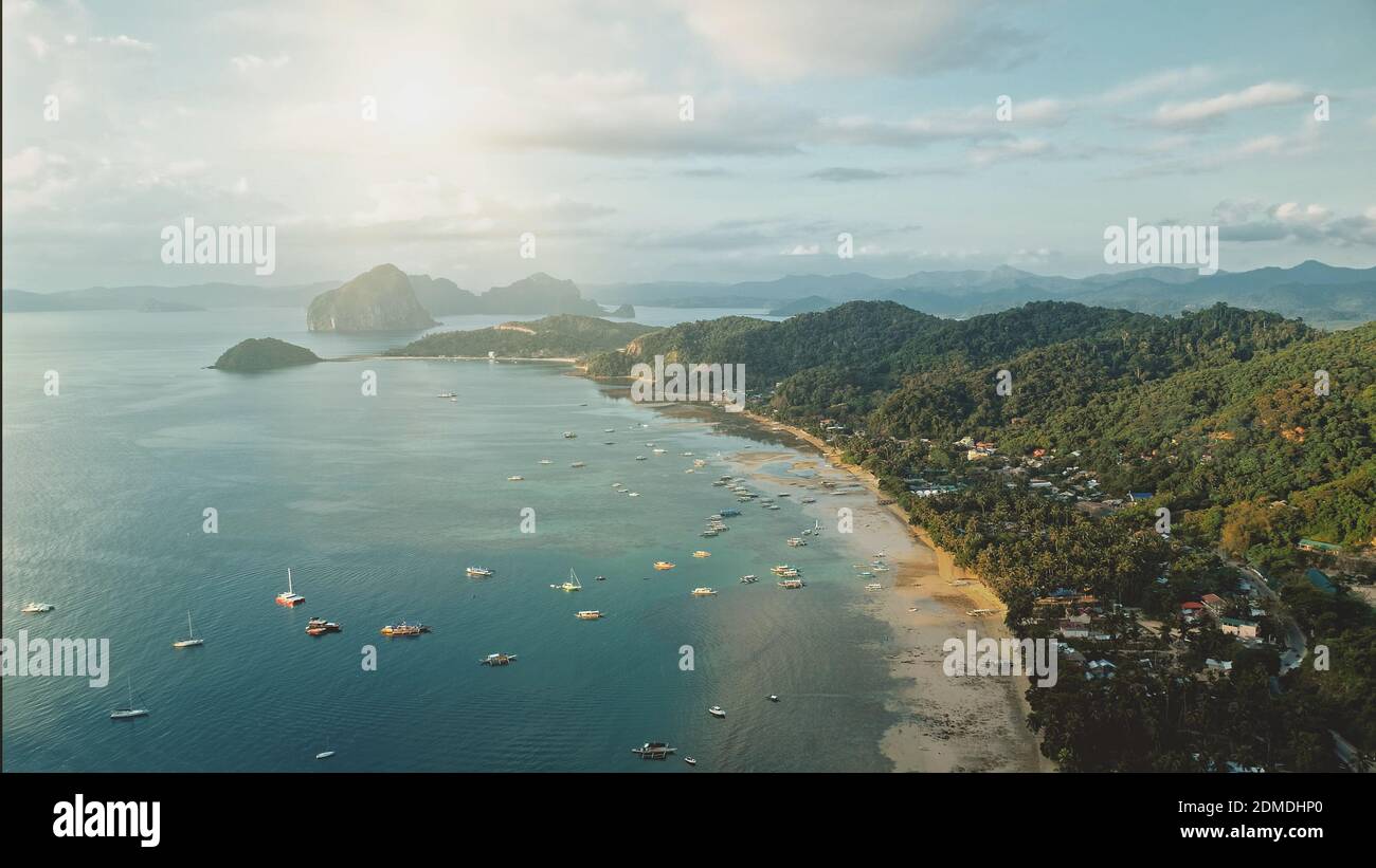 Ocean Pier Stadt Luftbild: Sonne Stadtbild mit vielen Booten, Schiffen, Schiffen am Wasser. Hütten und Hütten bei grünen Palmen auf Hügeln. Wassertransport im tropischen philippinischen Resort der Palawan Insel Stockfoto