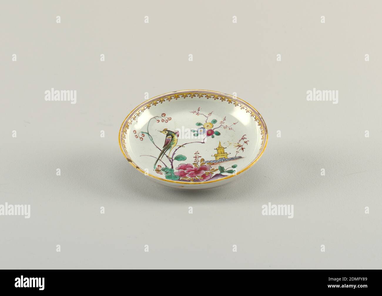 Untertasse mit Vogel, Blumen und Pagode, Fauchier Factory, Fayence, Untertasse aus rosa Buff Ton mit gräulichen Glasur. Polychrome Malerei des Vogels mit langem Schwanz auf blühenden Baumzweigblumen und Pagode. Am Rand, gelbe und braune Linien, die innerste erweitert zu Trifoils., Marseille, Frankreich, Mitte des 18. Jahrhunderts, Keramik, Dekorative Kunst, Untertasse, Untertasse Stockfoto