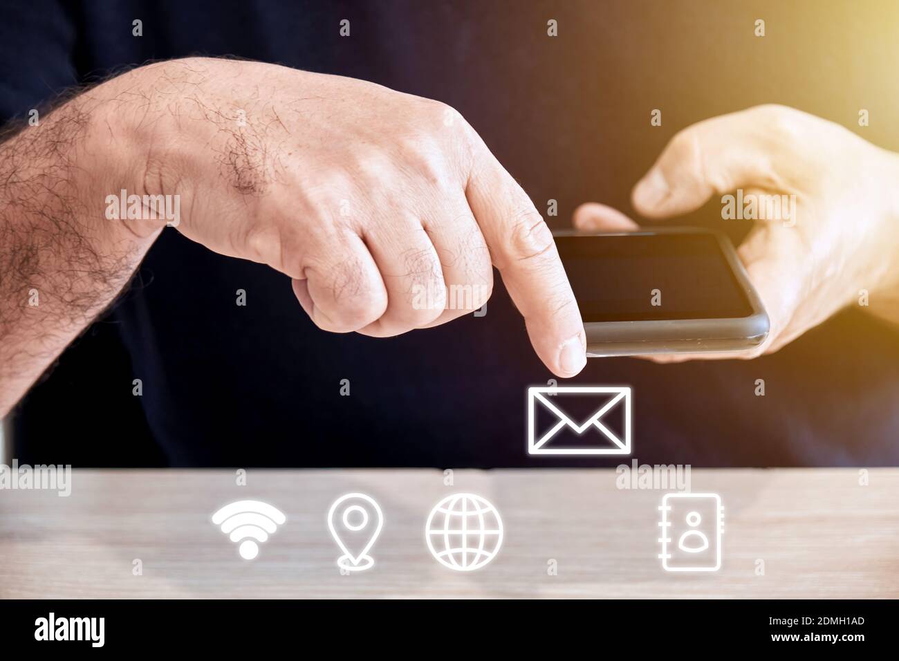 Männliche Person hält ein Mobiltelefon oder Smartphone in der Hand, wobei der Finger das Mail-Symbol berührt. Online-Unterstützung, Support und Messaging-Konzept. Stockfoto