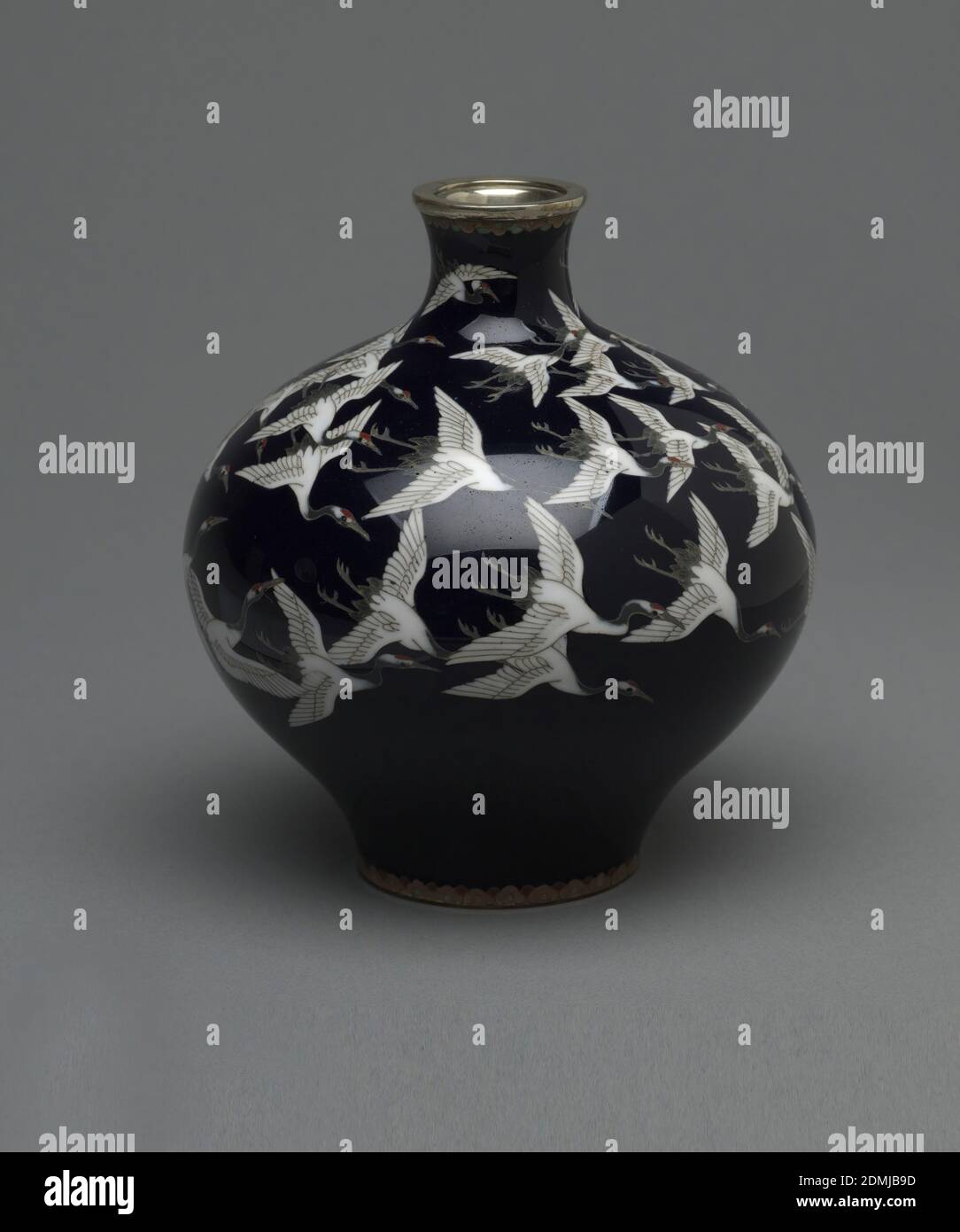 Vase, Emaille auf Kupfer, Nickel, EINE schwarze Zwiebelvase mit kleinem Hals. Vase zeigt einen Schwarm weißer Vögel, die um die Oberseite der Vase fliegen. Sowohl Ober- als auch Unterseite der Vase haben das gleiche, kleine, dekorative Band um sie herum., Japan, ca. 1870–80, Emaille, Dekorative Kunst, Vase Stockfoto Vase, Emaille auf Kupfer, Nickel, EINE schwarze Zwiebelvase mit kleinem Hals. Vase zeigt einen Schwarm weißer Vögel, die um die Oberseite der Vase fliegen. Sowohl Ober- als auch Unterseite der Vase haben das gleiche, kleine, dekorative Band um sie herum., Japan, ca. 1870–80, Emaille, Dekorative Kunst, Vase Stockfoto