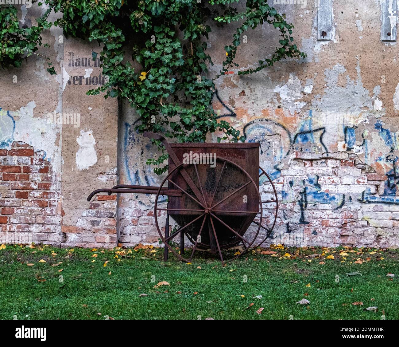 Der Aedes Netzwerk Campus Berlin, ANCB Hof und Freifläche, Christeninstraße, Prenzlauerberg, Berlin. Rostige Schubkarre & getherte Wand der AE Stockfoto