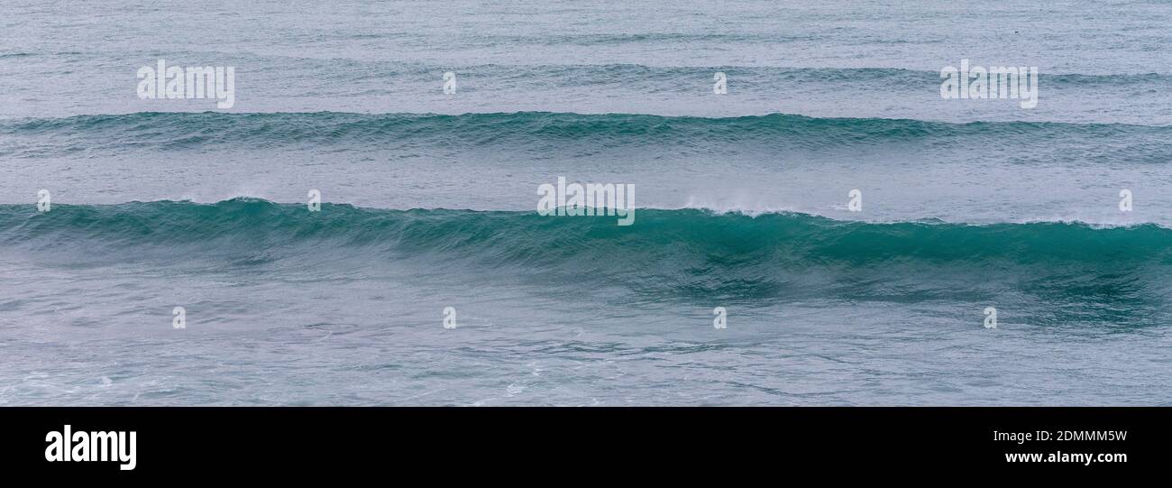 Eine Reihe von großen glasigen Wellen aus dem Boden schwellen Am Strand Praia do Portinho in Peniche Stockfoto