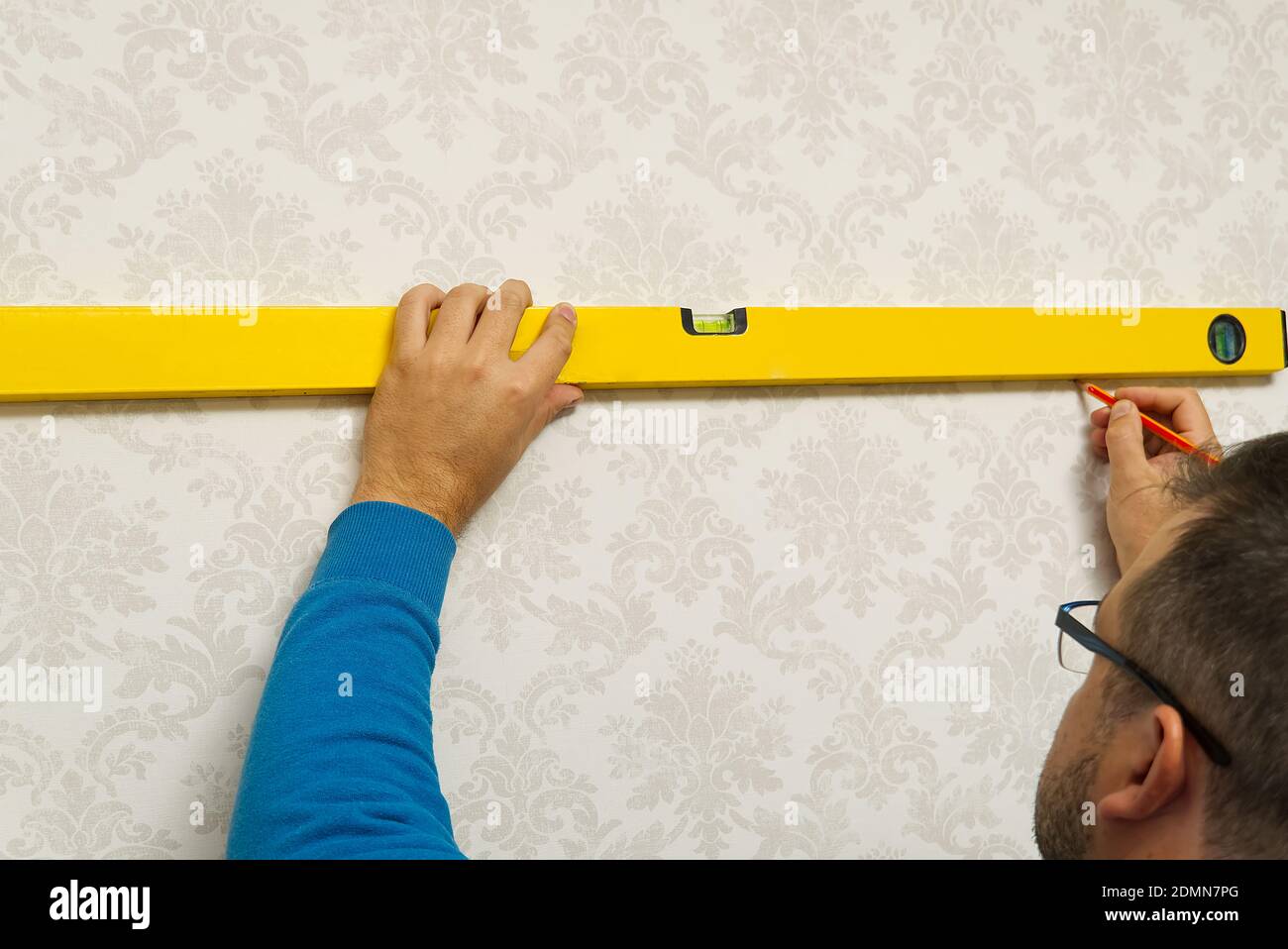 Der Master macht das Markup mit einer Blasenebene. Heimwerkerreparatur Stockfoto