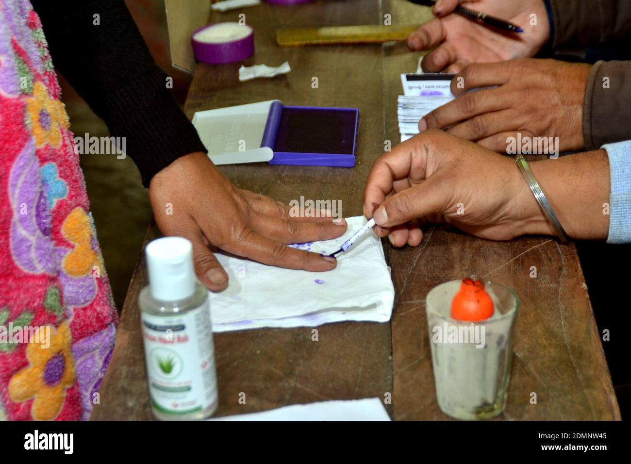 Nagaon, Assam, Indien - 17. Dezember 2020: Ein Wahlbeamter, der während der Tiwa-Wahl des Autonomen Rates im Dorf Kachamari im Bezirk Nagaon in Assam, Indien, mit der Markierung eines Wählers an einem Wahllokal beschäftigt war. Kredit: DIGANTA TALUKDAR/Alamy Live Nachrichten Stockfoto