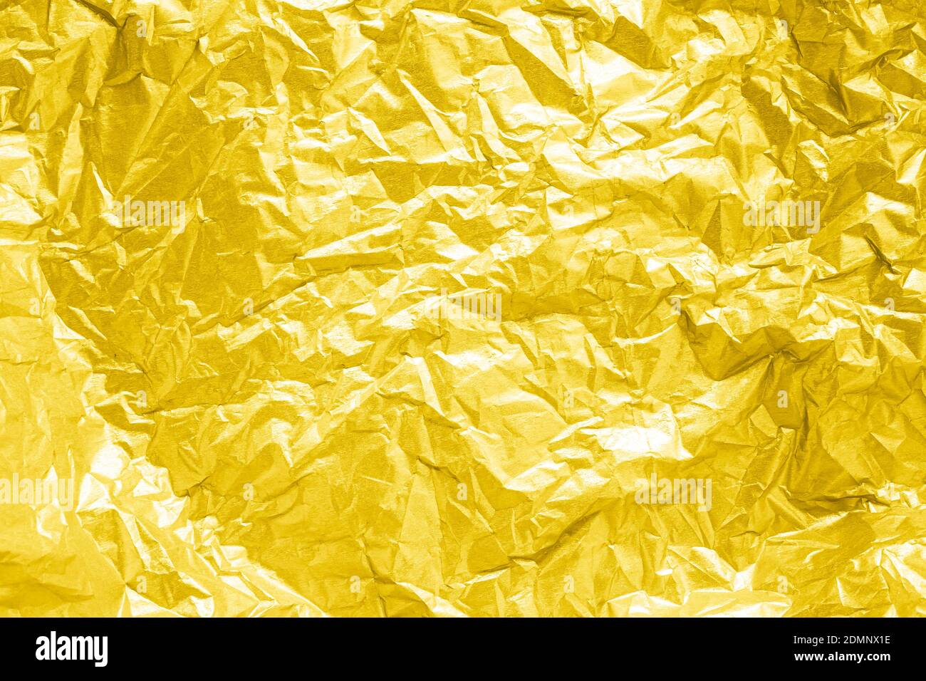 Abstrakt strukturierter gelber Hintergrund aus faltenem goldenem Papier Stockfoto