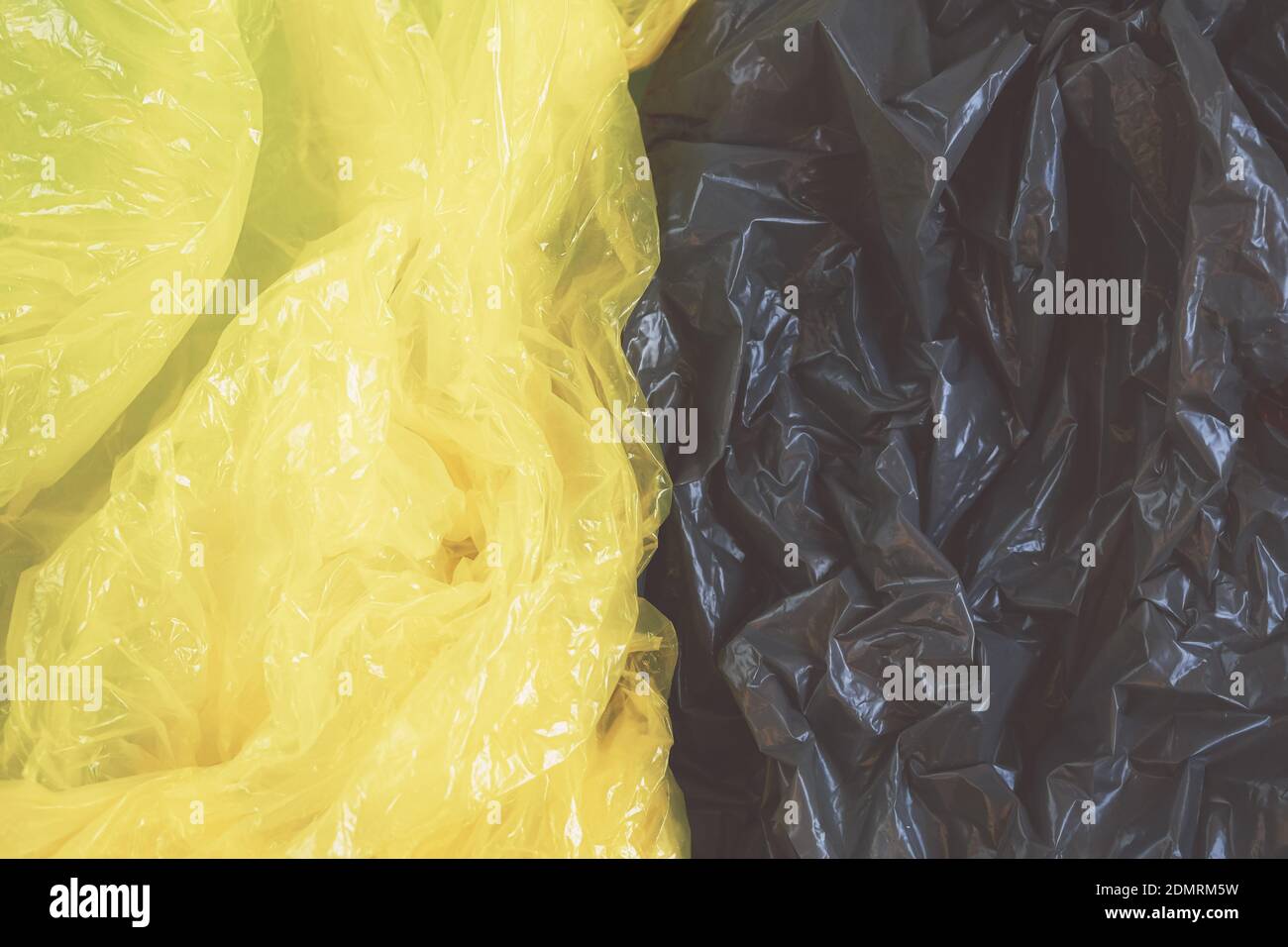 Leuchtende gelbe und ultimative graue Plastiktüten Hintergrund, eco, Abfall envitomental Verschmutzung Konzept. Stockfoto