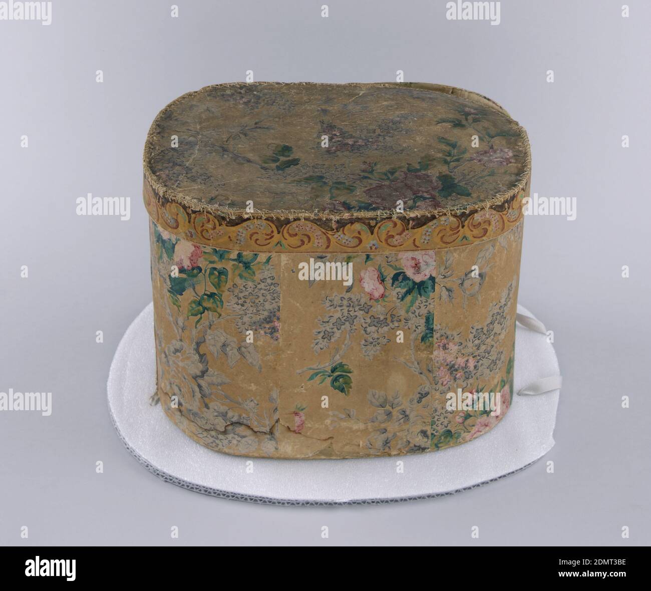 Bandbox, Jesse Baker, Blockdruckpapier auf Pasteboard-Unterstützung, inspiriert von bedrucktem Chintz, Design aus Flieder und Rosen in Lavendel und Rosa mit grünen Blättern auf braunem Hintergrund. Flieder in Ölfarben, Rosen und Blättern in Staupe. Auf dem Etikett auf der Innenseite des Covers steht: 'Von Jesse Baker, Paper Box Manfr. Nr. 21 Bank St. BET. Market & Chestnut & 2nd & 3rd, Phil-delphia.' Diese Kiste gehörte Sarah Kirk, Tante von Elyah Hollingsworth; präsentiert von seiner Enkelin, Mrs. Norton Paton, Irvington-on-Hudson, New York., Philadelphia, Pennsylvania, USA, 1800–1830, Wallcoverings, Bandbox Stockfoto