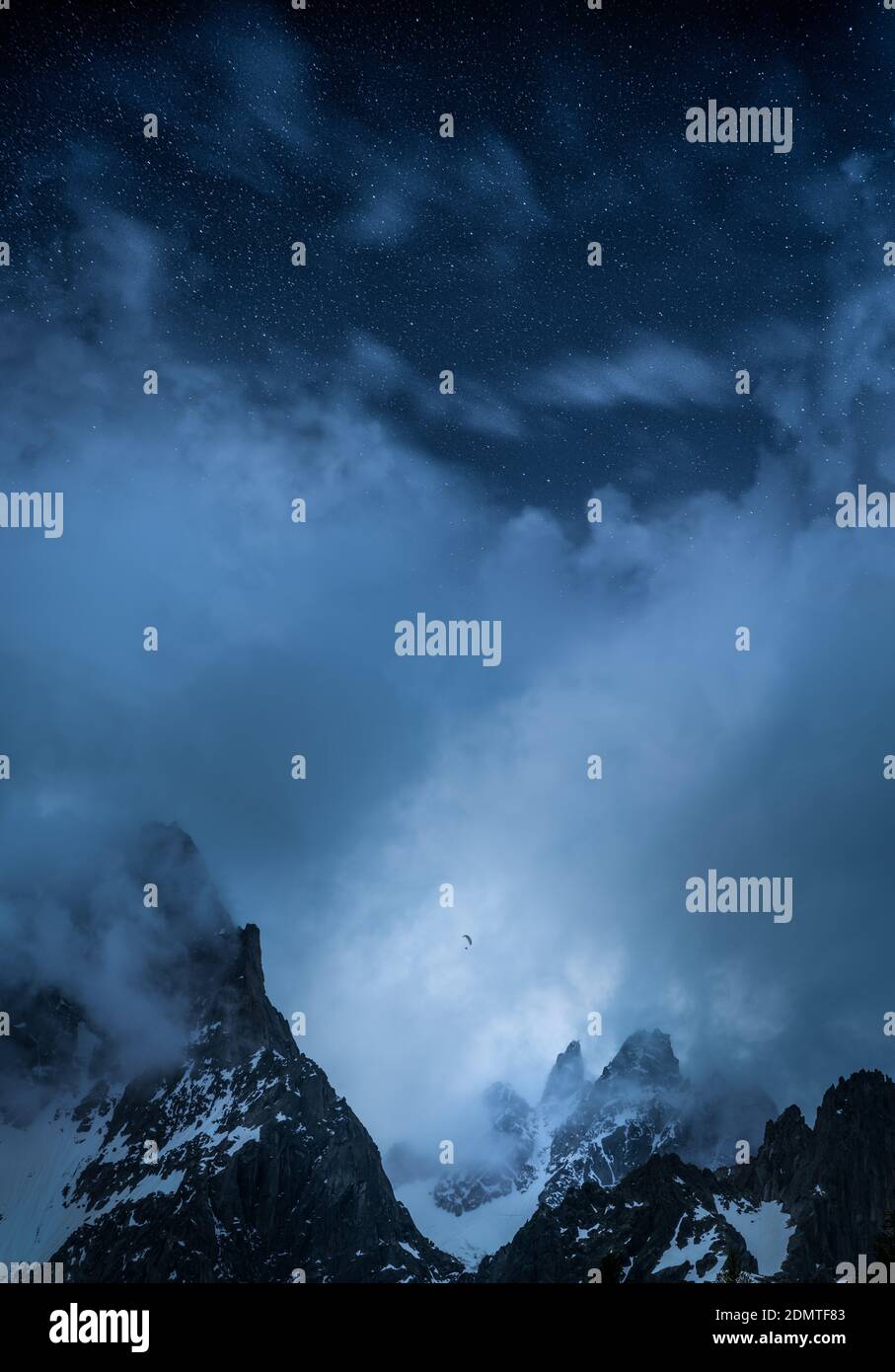 Ein epischer Blick auf Gleitschirm zwischen hohen Bergen und Unter Sternen Stockfoto