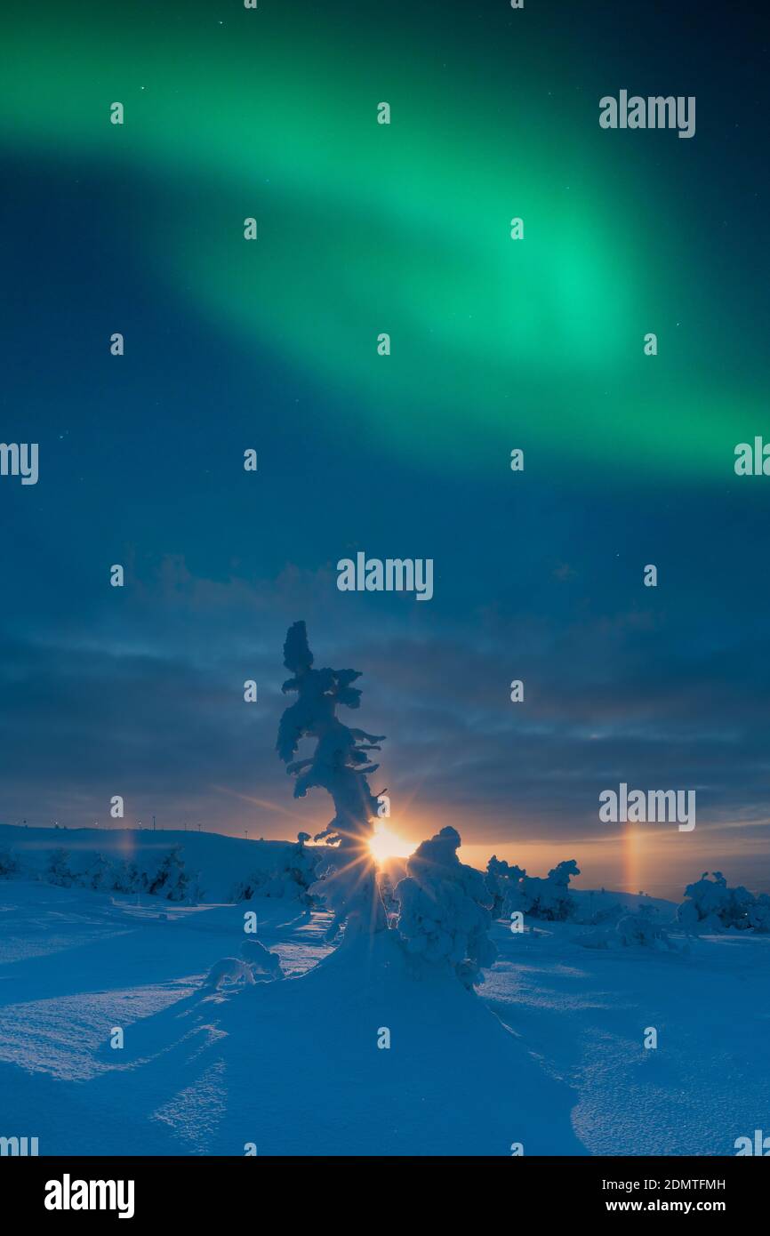 Nordlichter über einer Winterlandschaft bei Sonnenuntergang. Stockfoto