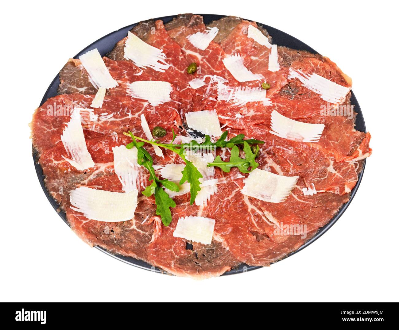 Portion Carpaccio (dünn geschnittenes Roh-Rinderfilet) verziert von Parmesan, Arugula und Kapern auf schwarzem Teller isoliert auf weißem Hintergrund Stockfoto