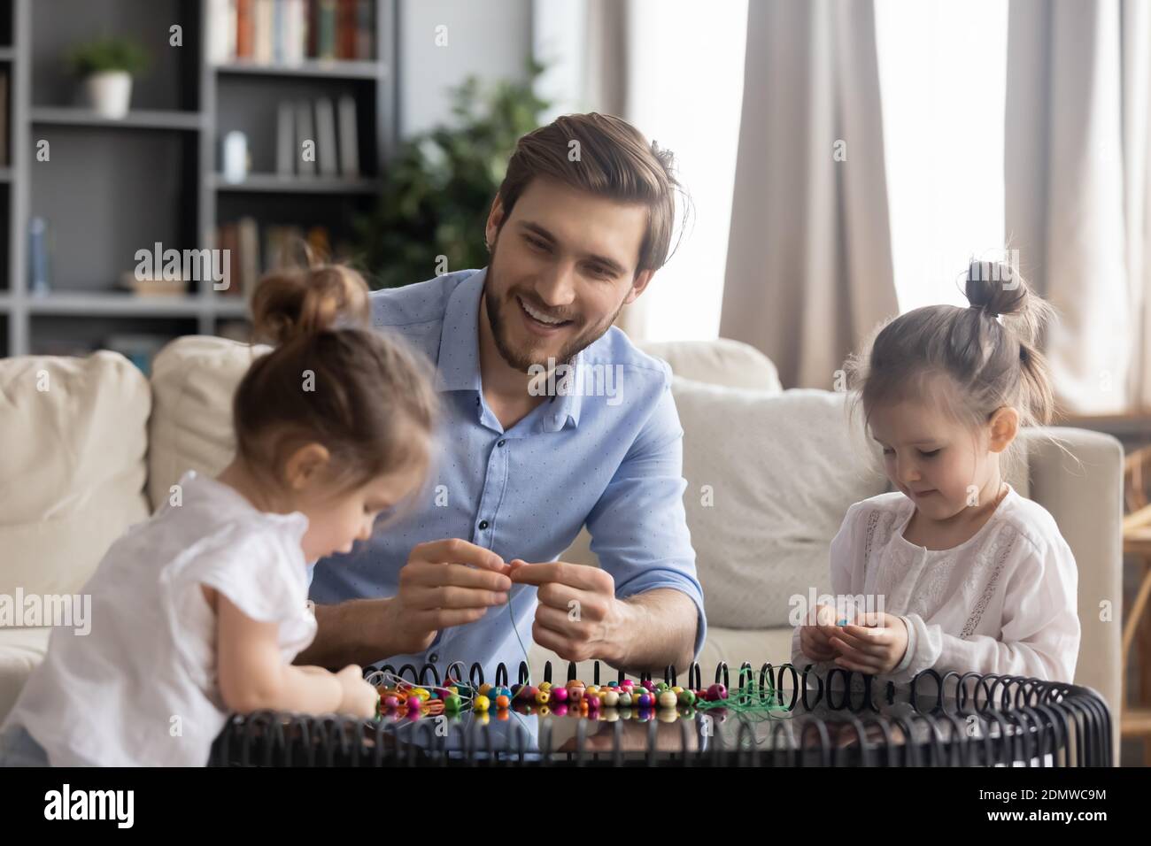 Liebevoller Vater engagiert in kreativer Tätigkeit mit Töchtern Stockfoto