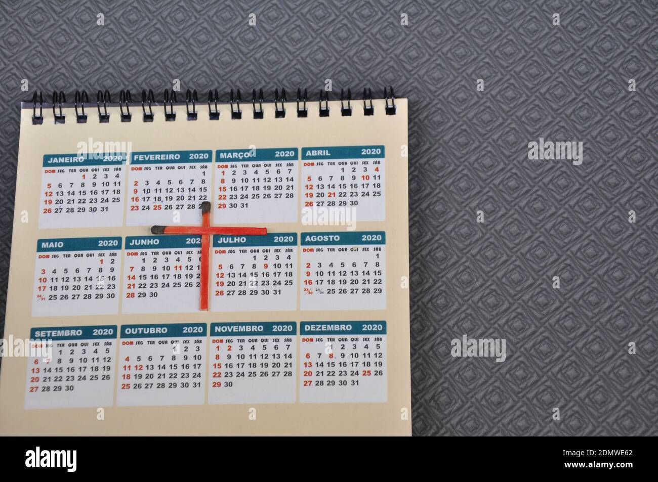 Kalender, auf farbigem bedrucktem Papier mit dem Jahr 2020, mit einem Kreuz aus roten Streichhölzer, Top-Down-Foto, Zoom-Foto, Konzeptfoto Stockfoto
