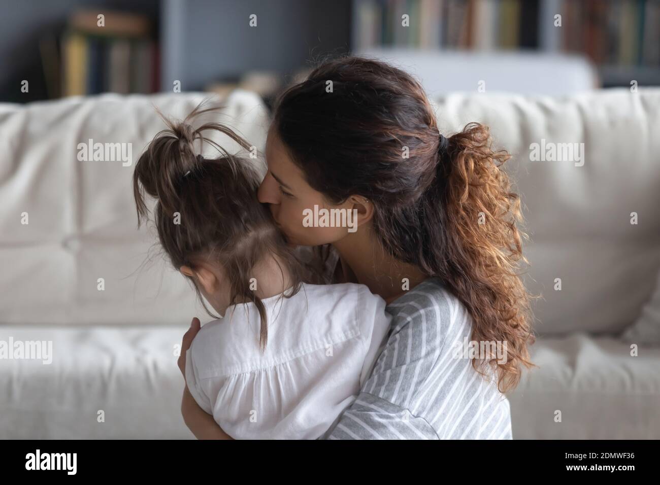 Liebevolle Mutter Umarmung und Kuscheln kleine Tochter Stockfoto