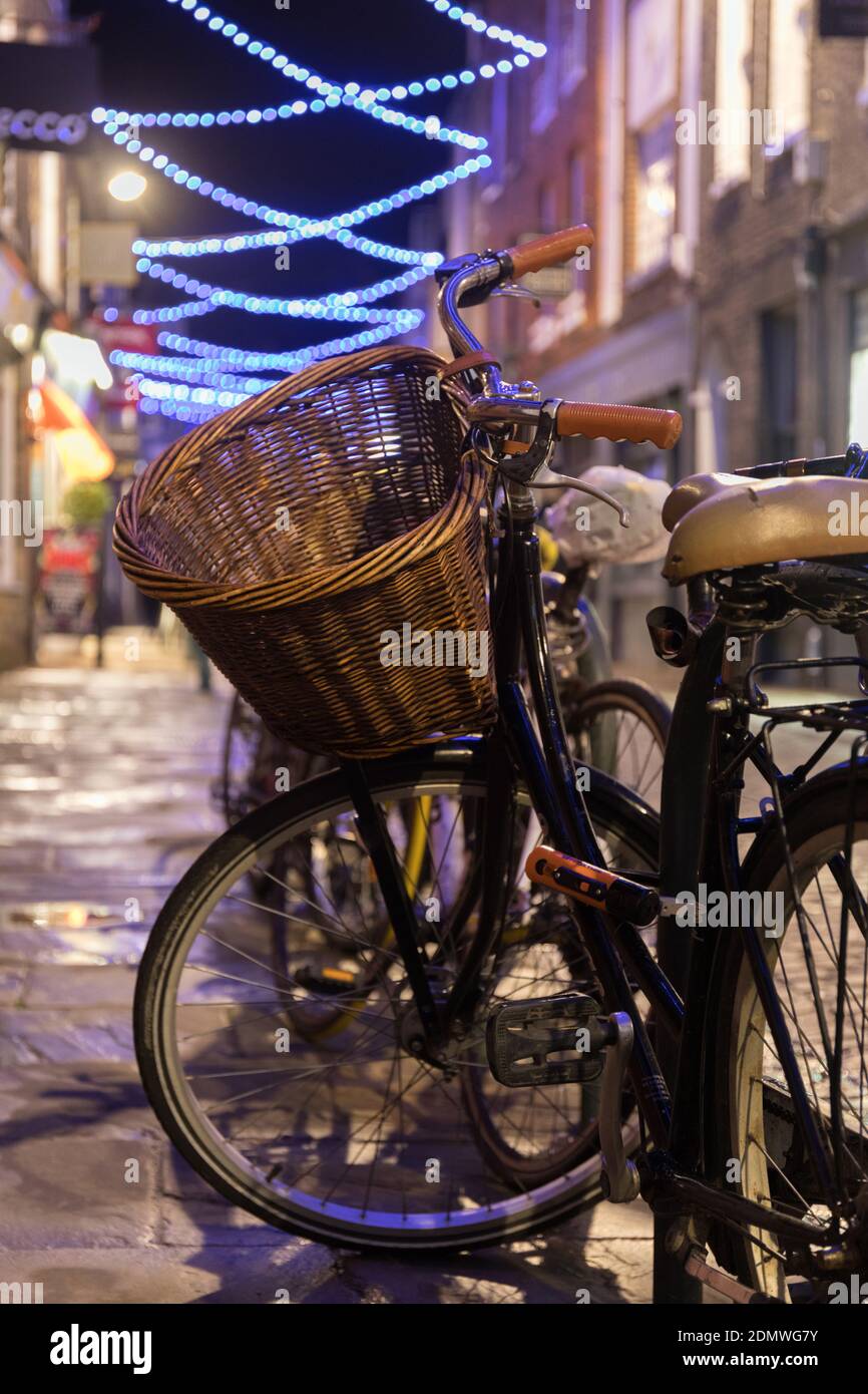 Fahrrad mit Korbkorb auf der Green Street Cambridge, mit Weihnachtsbeleuchtung auf der Straße Stockfoto