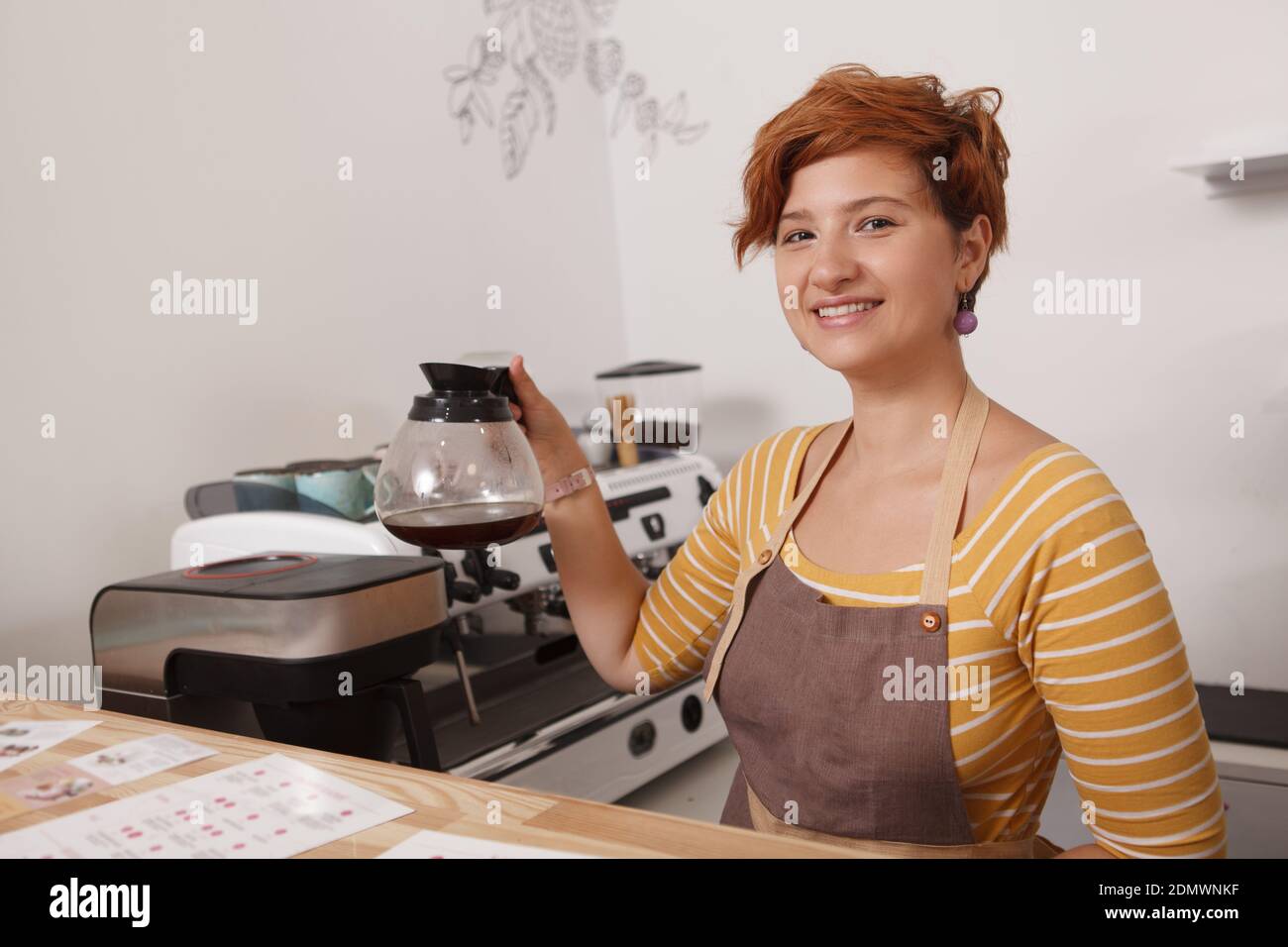 Ein kurzer Schuss einer Barista mit frisch gebrühtem Schwarz Kaffee in einer Glaskanne Stockfoto