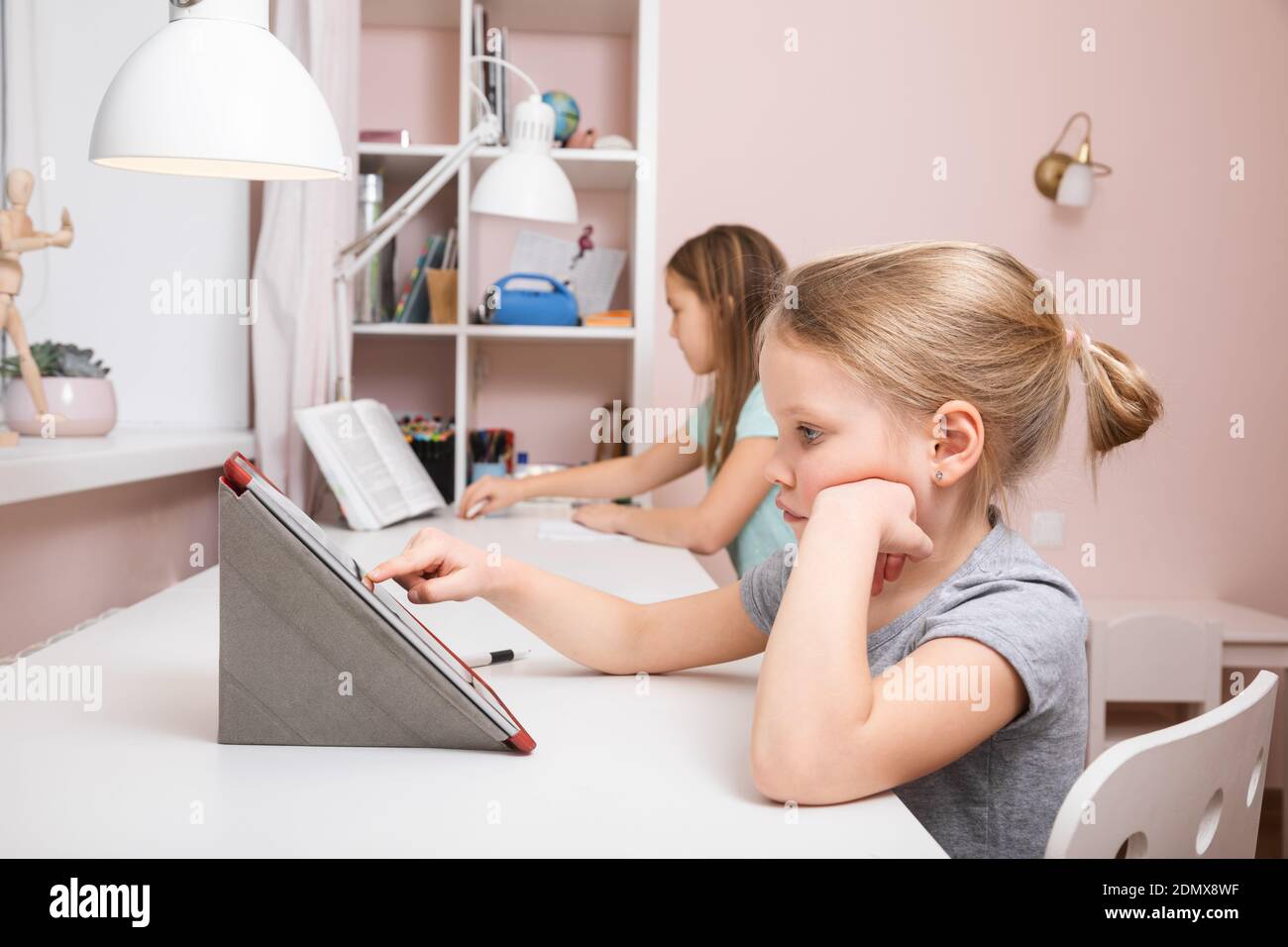Mädchen, die am Schreibtisch im Kinderzimmer sitzen und studieren Zu Hause Hausaufgaben während Coronavirus COVID-19 Quarantäne Stockfoto