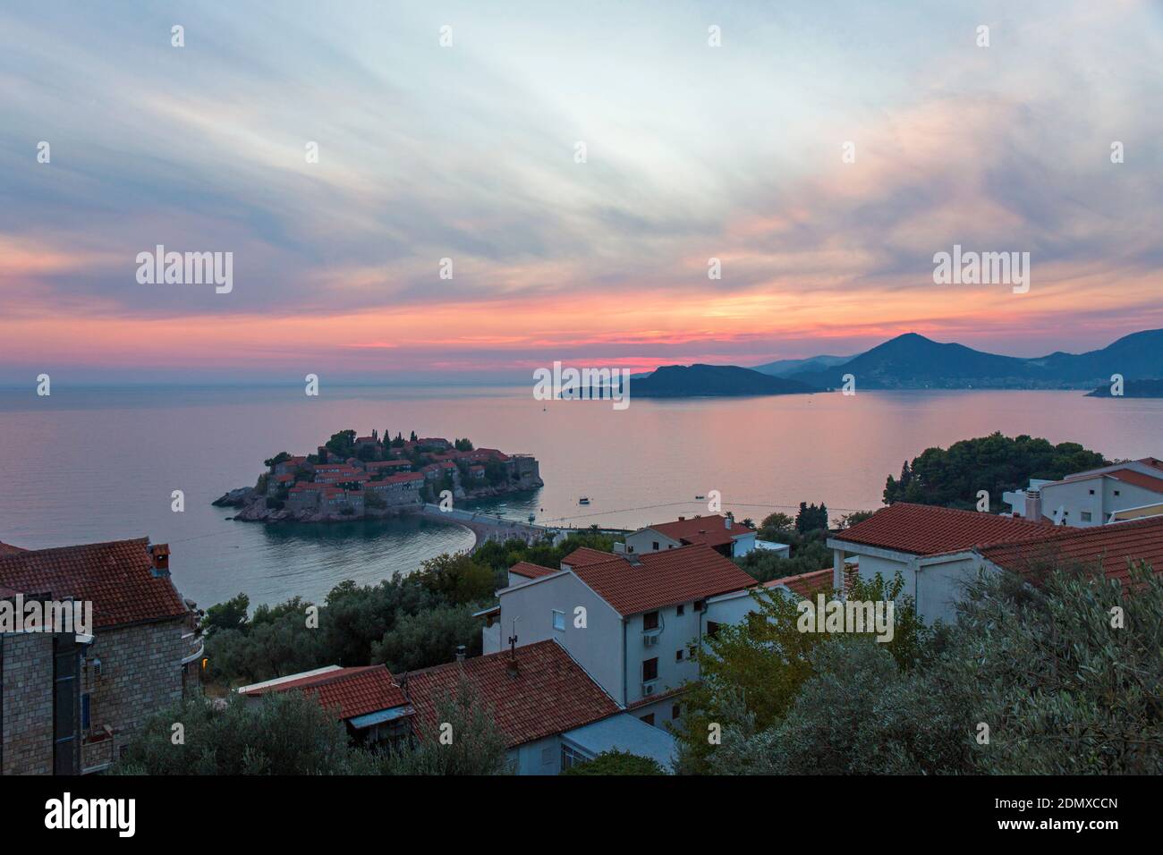 Sveti Stefan, Budva, Montenegro. Blick über die Dächer der Budva Bucht und das exklusive Inselresort Sveti Stefan, Abenddämmerung. Stockfoto