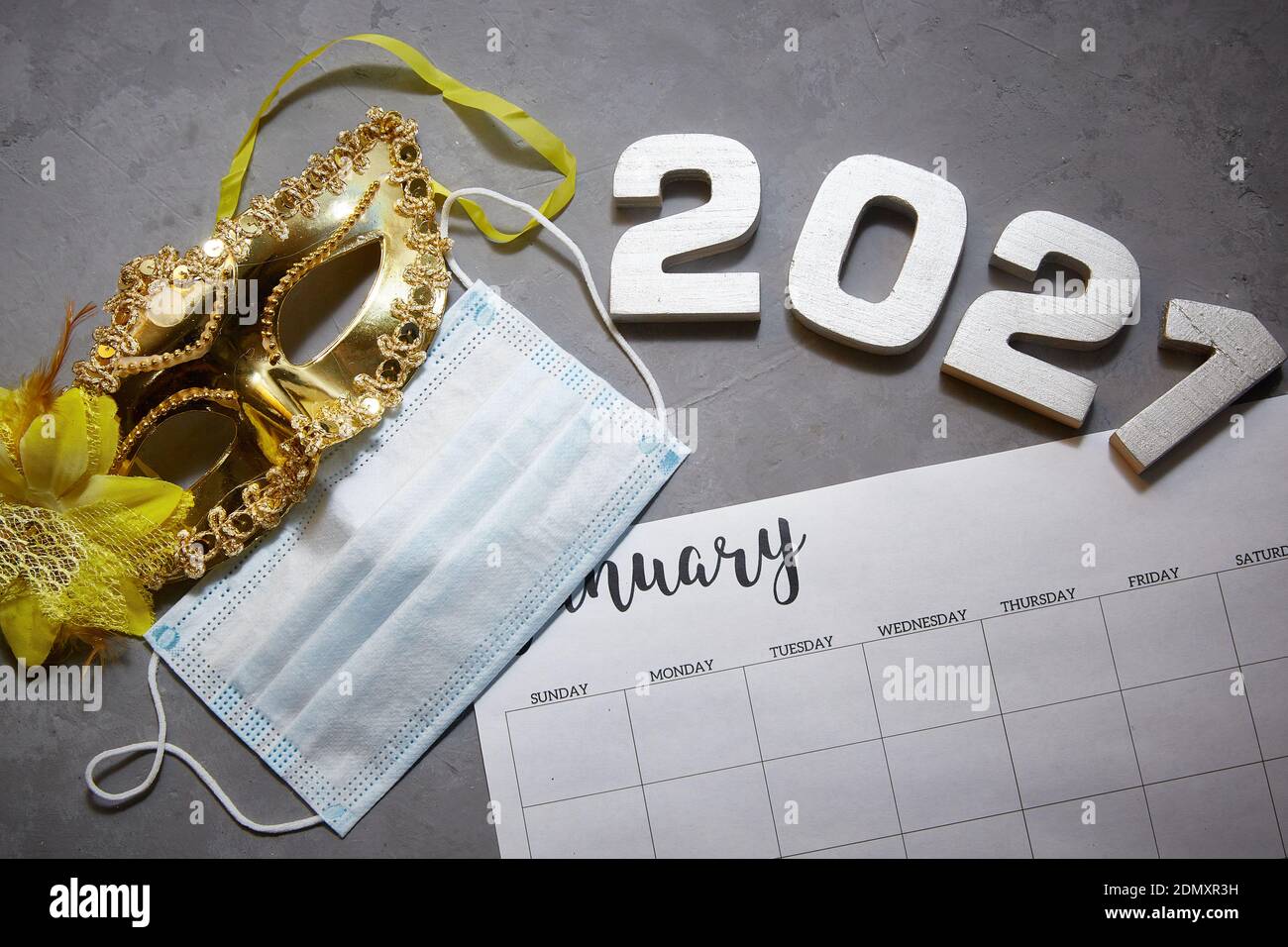 Kalender für Januar 2021. Karneval und eine medizinische Maske. Konzept des neuen Jahres 2021. Hintergrund. Stockfoto
