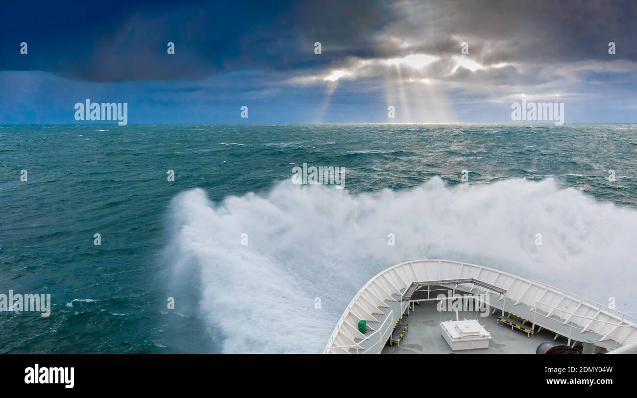 Lindblad's MS National Geographic Explorer in schweren Wellen in der vor der Küste von Spitzbergen mit Sonnenstrahlen (Gott Strahlen oder Sonnenstrahlen). Stockfoto