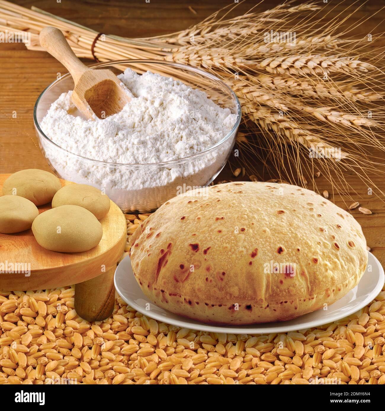 Weizenmehl, Chapati, Roti, Weizenohren, getrocknete Körner, Mehl in Terracota Schüssel. Getreideernte, Backwaren. Stockfoto