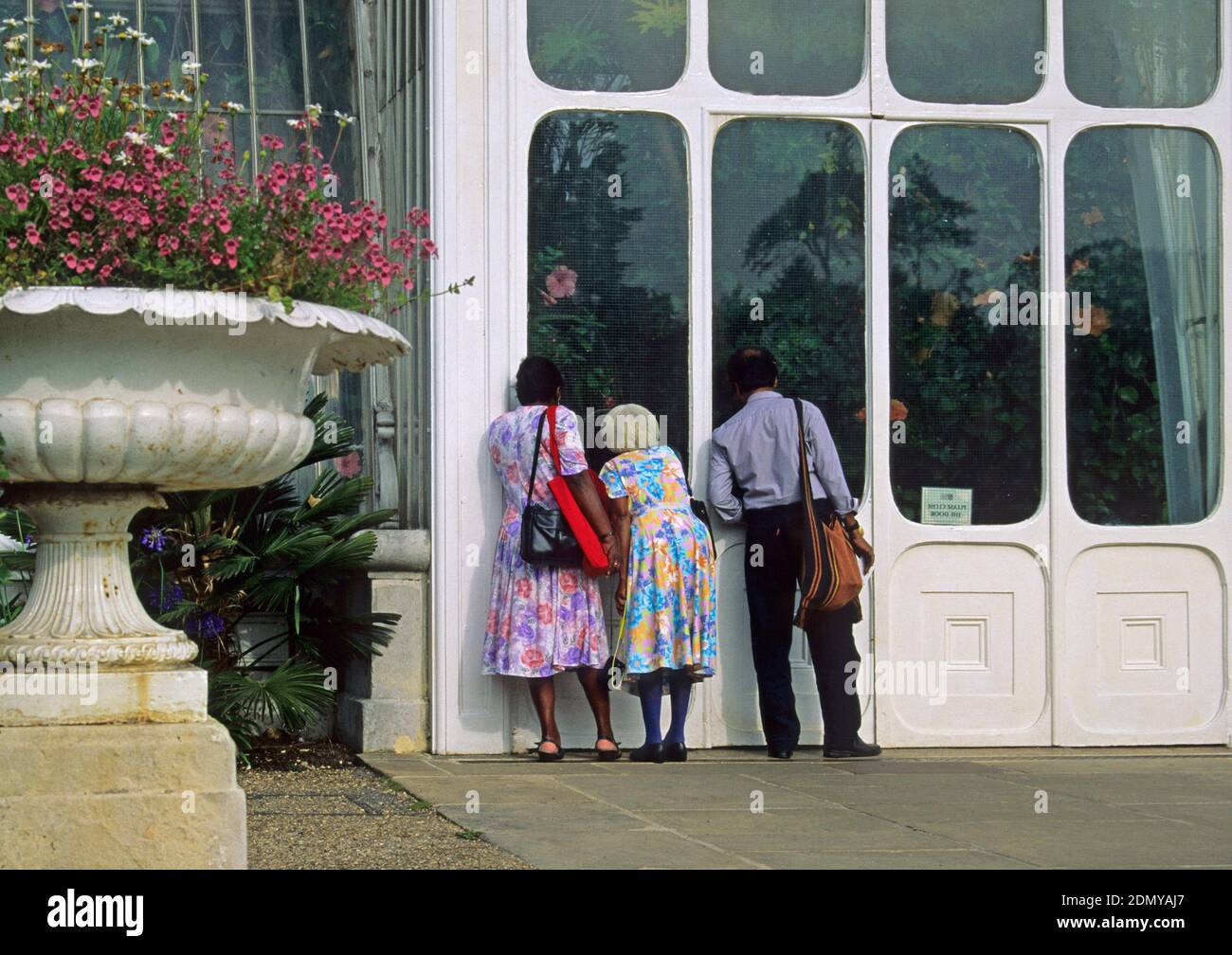 afro-karibische Besucher außerhalb des Gewächshauses in den Kew Gardens, Surrey, England Stockfoto