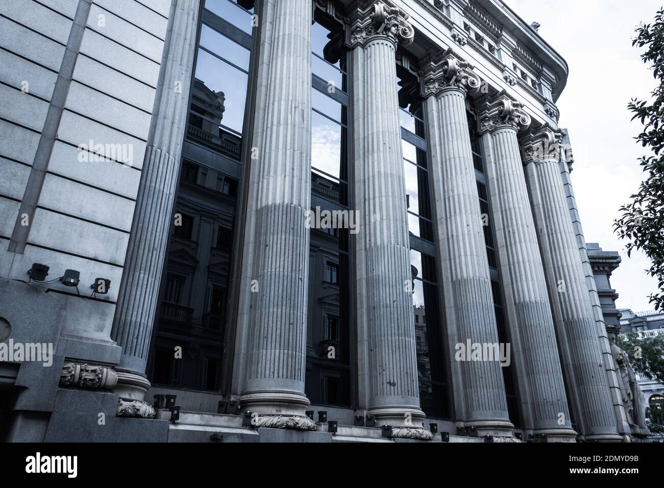 Große Säulen von Cervantes Institut Seitenfassade in Madrid. Spanische öffentliche Einrichtung. Eklektisches Architekturkonzept, kaltblauer Effekt angewendet Stockfoto