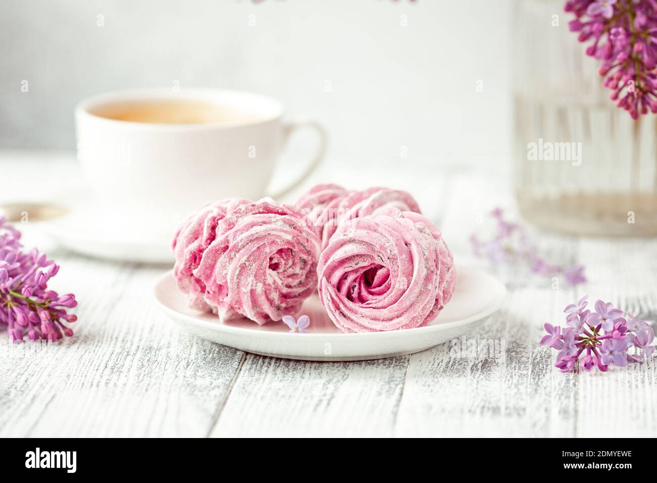 Flieder, Kaffee und hausgemachtes rosa Marshmallow auf weißem Keramikplatte. Romantischer Frühlingsmorgen. Selektiver Fokus - Bild Stockfoto