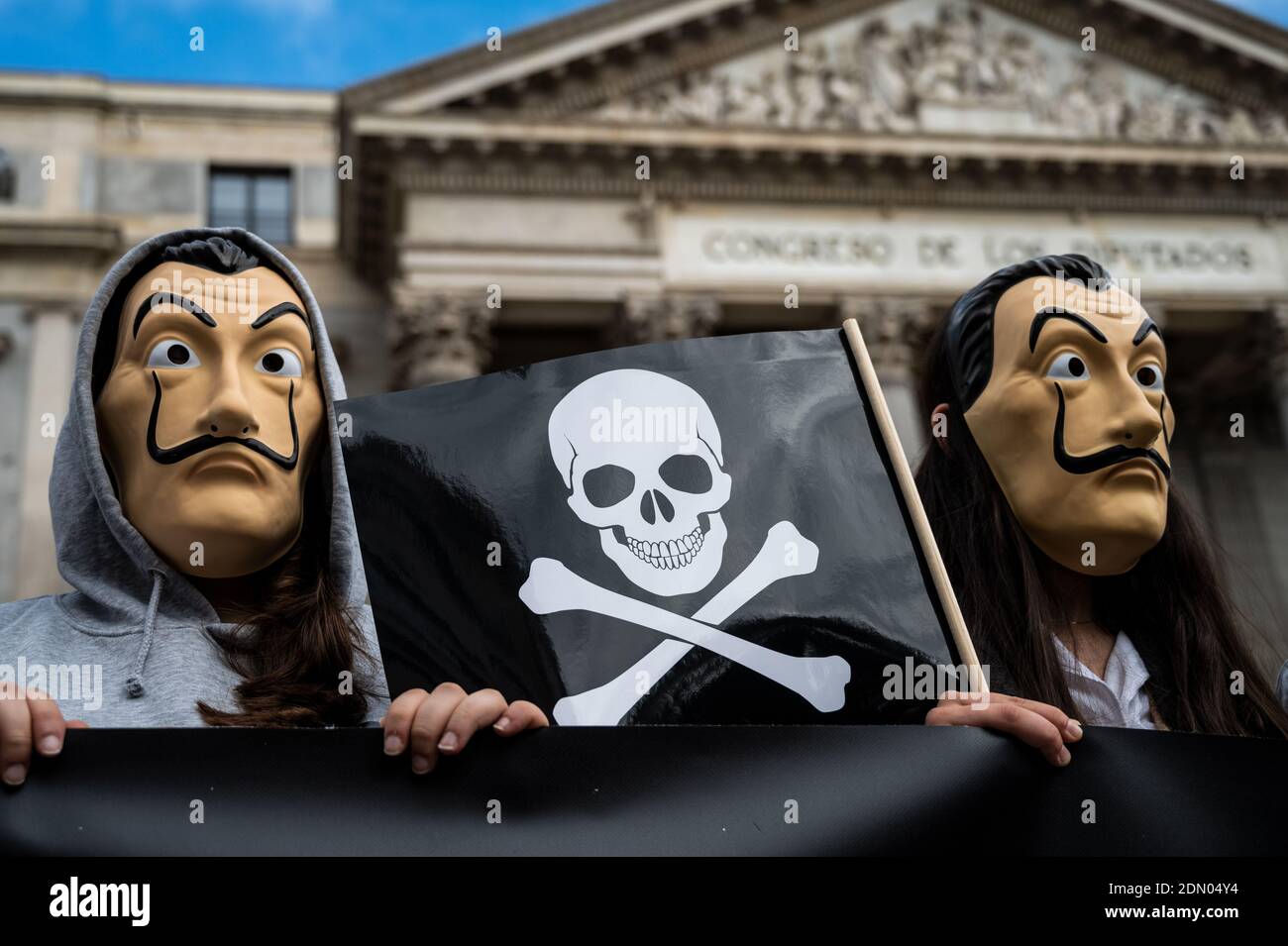 Madrid, Spanien. Dezember 2020. Demonstranten mit Gesichtsmasken von Dali, die eine Flagge mit Schädeln tragen, während einer Demonstration gegen Euthanasie vor dem spanischen Parlament, da erwartet wird, dass heute ein Gesetz zur Regelung der Euthanasie verabschiedet wird. Der Protest wurde von der Katholischen Rechtsanwaltskammer und der rechtsextremen Partei VOX unterstützt. Quelle: Marcos del Mazo/Alamy Live News Stockfoto