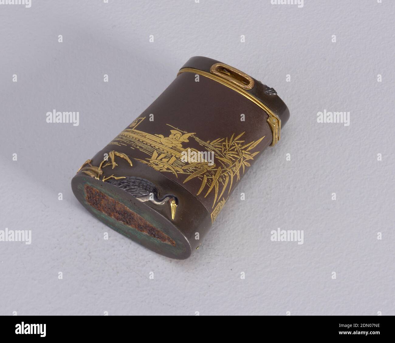Schwerthilt mit Fischerbooten und Wasservögeln, Shakudo, Gold, in Form eines Schwerthilts, dunkelbraun, mit schrägen Seiten, ovaler Deckel mit kleiner Rautenform, goldgerahmte Öffnungen auf Vorder- und Rückseite; Größere ovale Basis mit flachem Boden, etwas breiter als der zentrale Kastenkörper und von einer Naht, die von vorne nach hinten verläuft, abgestanzt; Körper mit eingelegten Goldverzierungen mit Fischern, Flussbooten, Kormoranen und Bambusblättern; Oberseite des Deckels mit aufgehobenem Gold und Shakudo-Verzierung von Kormoran im Flug; Basis verfügt über erhöhte Gold und Shakudo Dekoration von watenden Vogel und Laub. Deckel Stockfoto