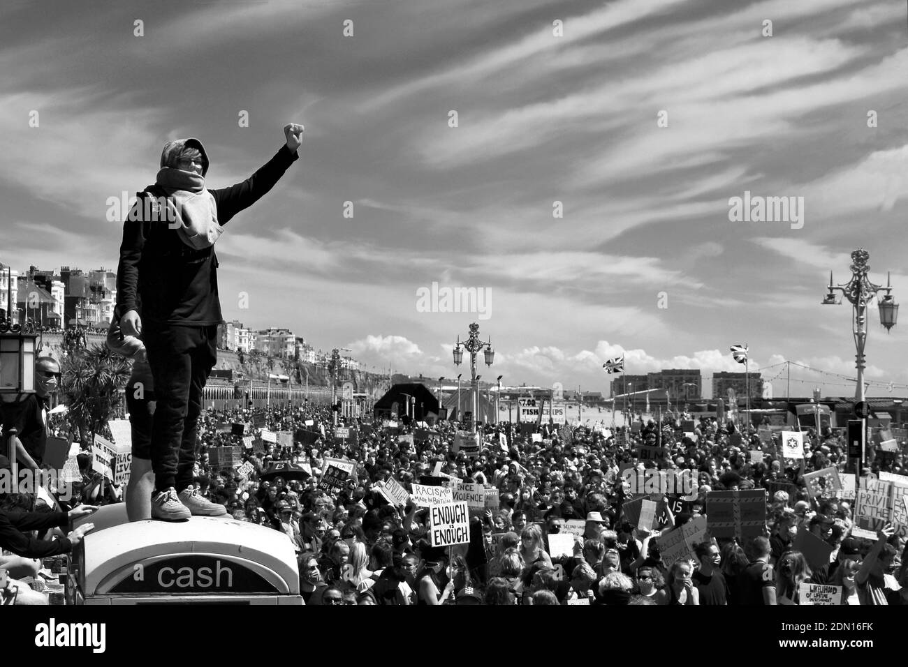 Black Lives Matter in schwarz und weiß - Frau, die mit erhobener Faust über der Menge steht. Stockfoto