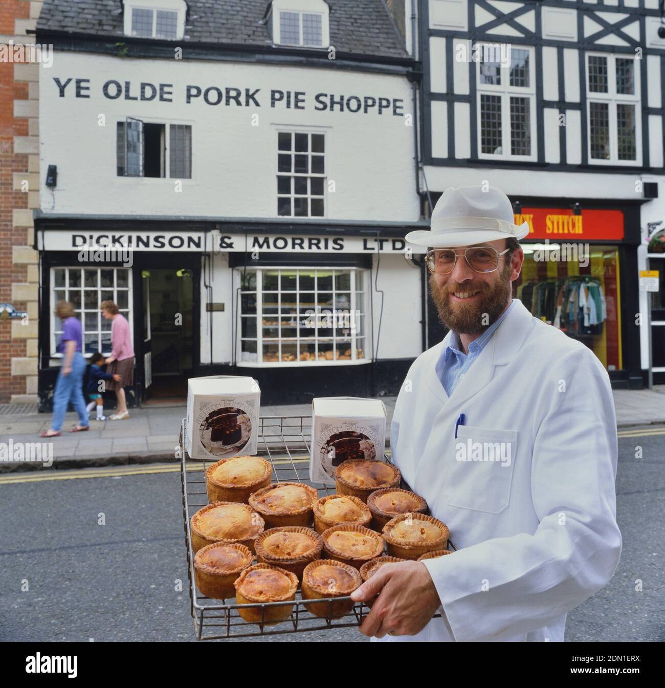 Ein Bäcker hält ein Tablett mit Melton Mowbray Schweinebraten & Melton Hunt Kuchen außerhalb Ye Olde Pork Pie Shoppe. Melton Mowbray. Leicestershire. England, Großbritannien Stockfoto