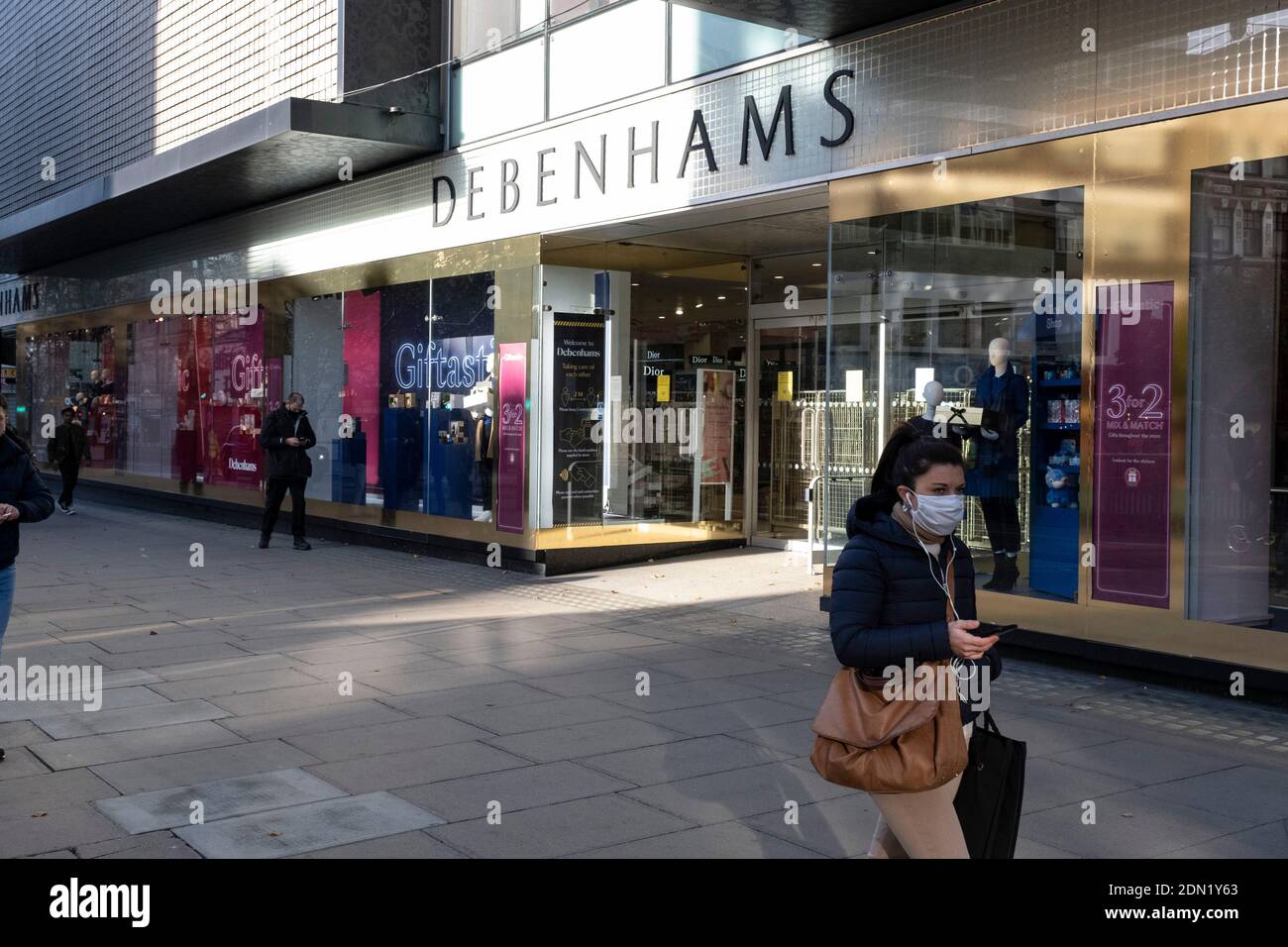 Die Menschen passieren Debenhams Flagship-Kaufhaus in der Oxford Street, als bekannt gegeben wird, dass Gespräche zur Rettung des Unternehmens am 1. Dezember 2020 in London, Großbritannien gescheitert sind. Debenhams ist seit 242 Jahren ein allgegenwärtiges Feature in ganz Großbritannien, aber es wurde angekündigt, dass es alle seine Geschäfte zum Preis von rund 12,000 Arbeitsplätzen schließen und in Liquidation gehen wird. Dieser große Schlag auf die Hauptstraße ist nicht überraschend, da das Unternehmen seit einiger Zeit kämpft. Stockfoto