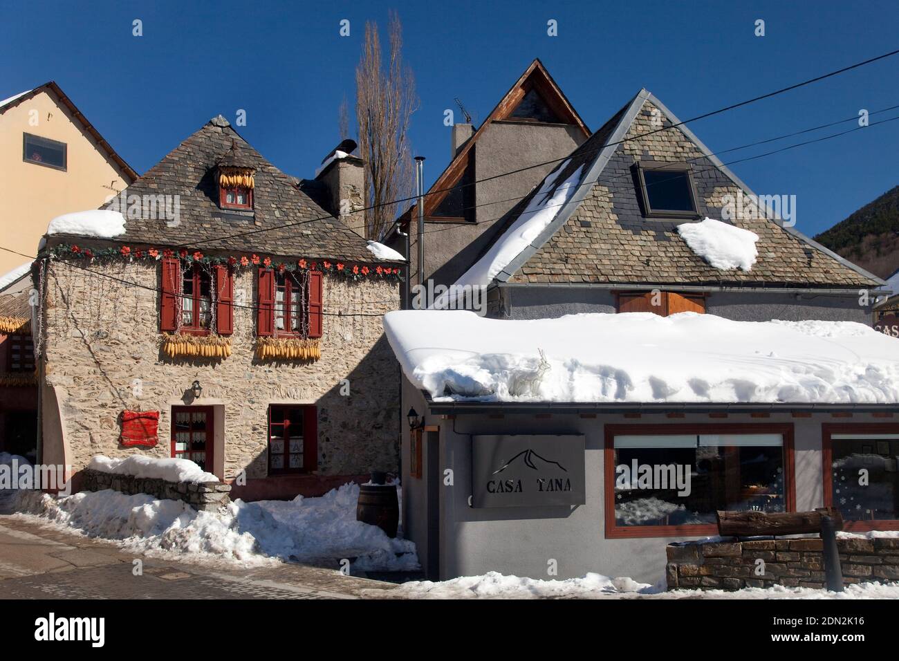 Horizontale bunte Blick auf einige Berghäuser und Casa Tana Restaurant in dem schönen Dorf von Schnee bedeckt, Artíes, Vall d’Aran, Lleida Stockfoto