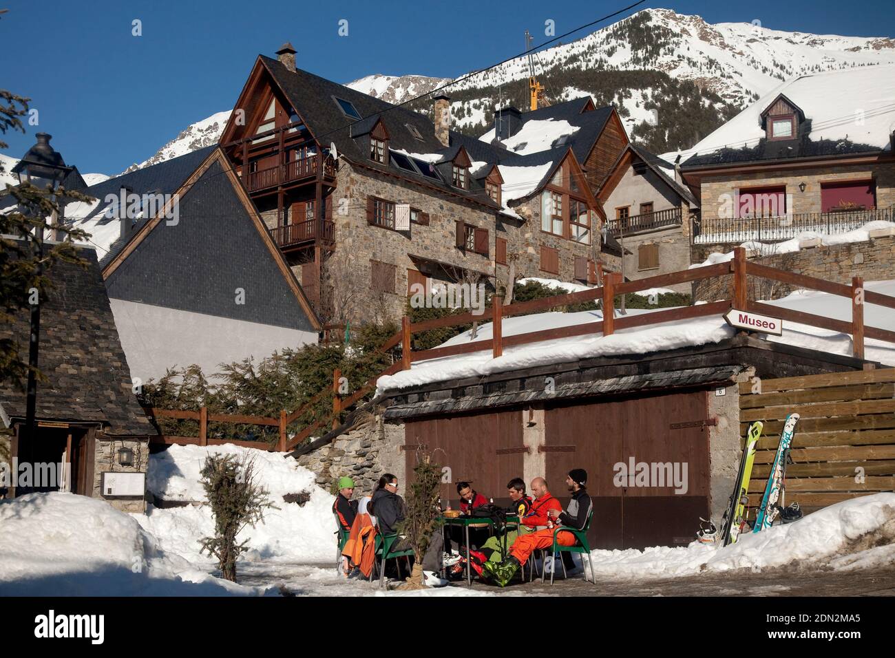 Gruppe von Skifahrern, die sich auf dem Hauptplatz von Bagergue in der Nähe des Museumseingangs, Vall d’Aran, Lleida, Katalonien, Spanien, ausruhen Stockfoto