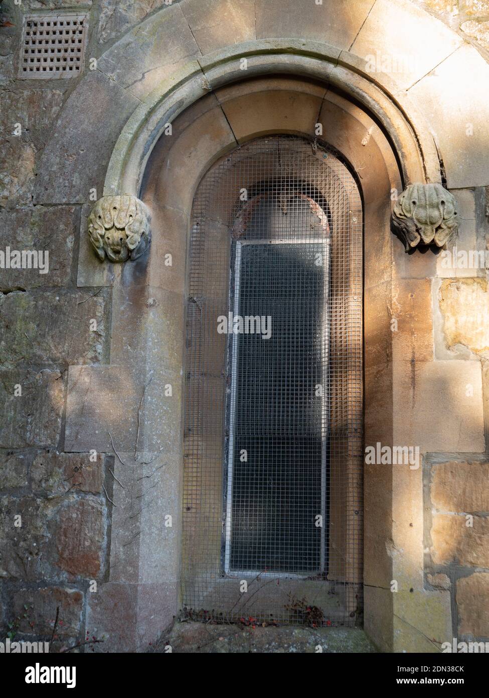 Rundes Bogenfenster mit umklammenden Strebepfeilern auf der Holy Trinity Church, Dilton Marsh, Wiltshire, England, UK. Stockfoto