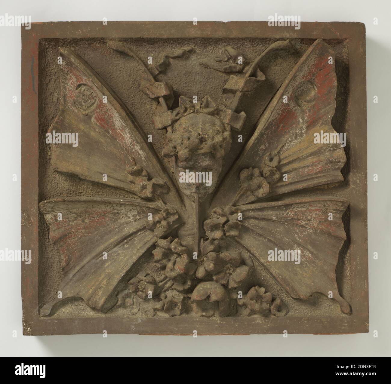Architektonisches Element, Terracotta, EINE quadratische Fliese mit flachem Rand. In der Mitte ein Kopf mit Antennen und Schmetterlingsflügeln. Blumen unten. Spuren von polychromer Dekoration., Frankreich, ca. 1890, Keramik, Dekorative Kunst, architektonisches Element Stockfoto