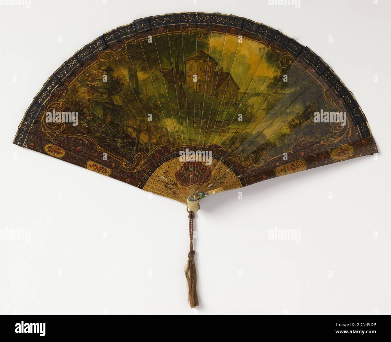 Brisé-Fächer, bemalte und vergoldete Elfenbeinstifte, Seidenband, vergoldeter Metallbügel, Perlmutt an Niete, Haartassel, Brisé-Fächer. Elfenbeinstifte, die dem "Vérnis martin" ähneln und Blumen und Vergoldungen entlang der Grenze zeigen, sowie eine große zentrale Kartusche mit Figuren im Stil des 18. Jahrhunderts in einem Garten mit Musiker. Verbindungsband aus Seide. Vergoldete Metallöse und Perlmutt am Niet. Haartassel., Frankreich, 1875–1900, Kostüm & Accessoires, Brisé-Fan Stockfoto