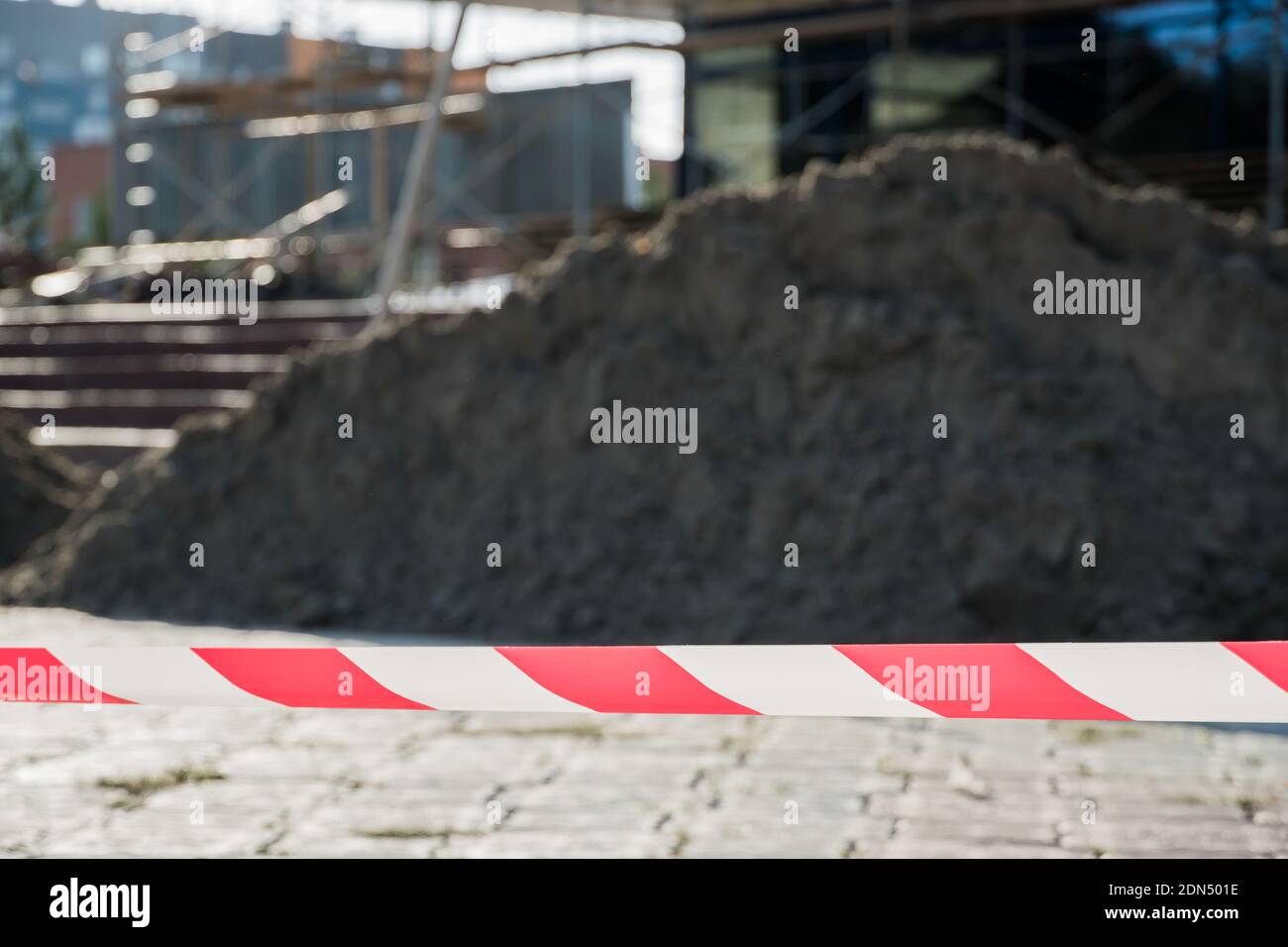 Rote und weiße Linien des Schutzbandes warnen vor Gefahren während des Baus und der Reparatur von Gebäuden. Rot und weiß Warnung Tape Pol Guard schützt Stockfoto