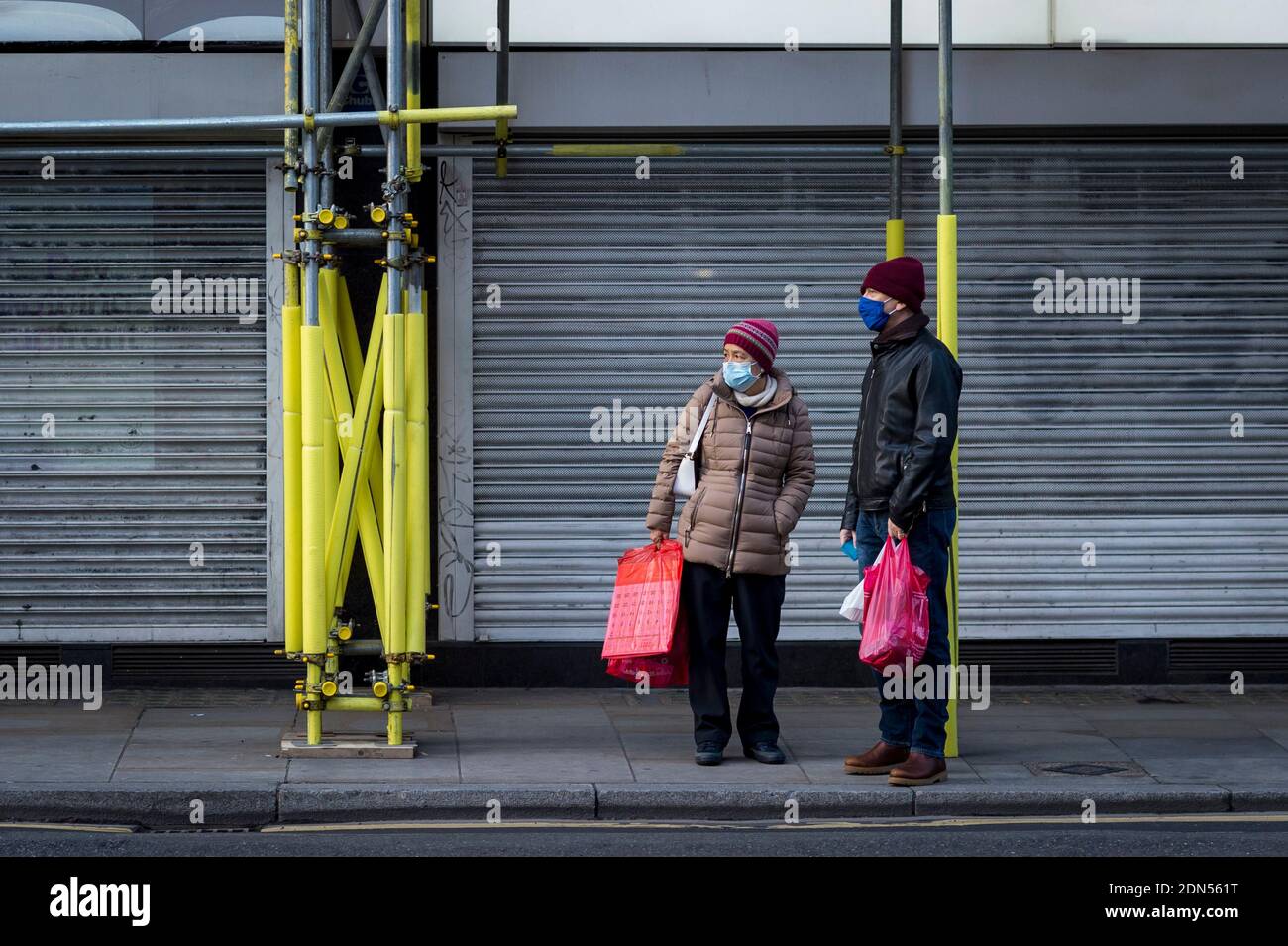 London, Großbritannien. 17 Dezember 2020. Ein Paar trägt Gesichtsmasken in Chinatown. Shaftesbury Plc, Eigentümer von Immobilien in Soho, Covent Garden, Carnaby Street und Chinatown, hat angekündigt, dass es den Wert seiner Londoner Restaurants, Bars und Geschäfte um fast 700 Millionen GBP (932 Millionen USD) aufschreibt. Da die Mieteinnahmen um 24 % gesunken sind und die Geschäfte während der laufenden Coronavirus-Pandemie Schwierigkeiten haben, den Handel zu halten. Der Kapitalzustieg auf Stufe 3 sehr hohe Alarmstufe wird nur dazu dienen, die Situation zu verschärfen. Kredit: Stephen Chung / Alamy Live Nachrichten Stockfoto