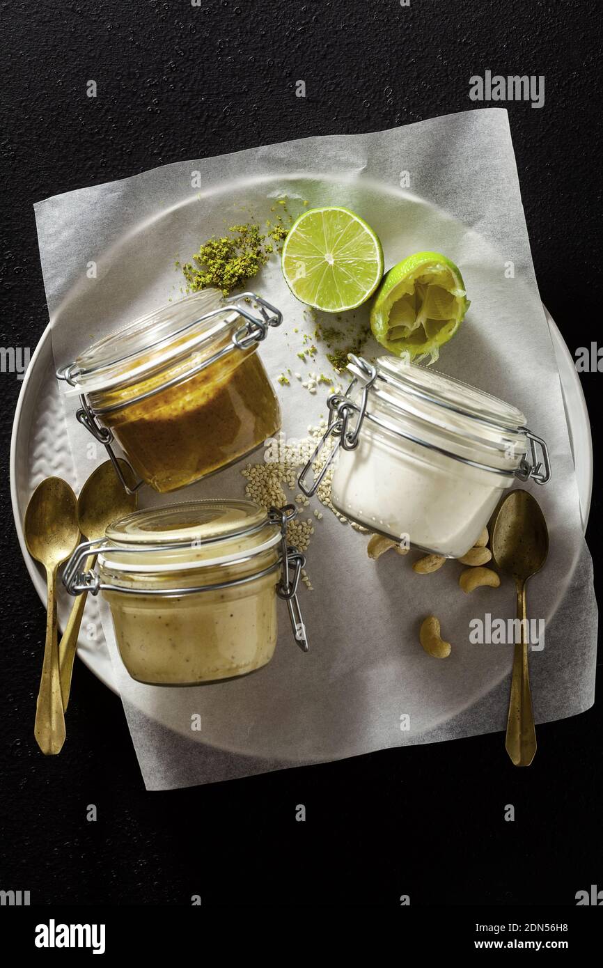 Verschiedene Saucen in Gläsern. Mit Pistazien, Cashews und veganem Mayo. Stockfoto
