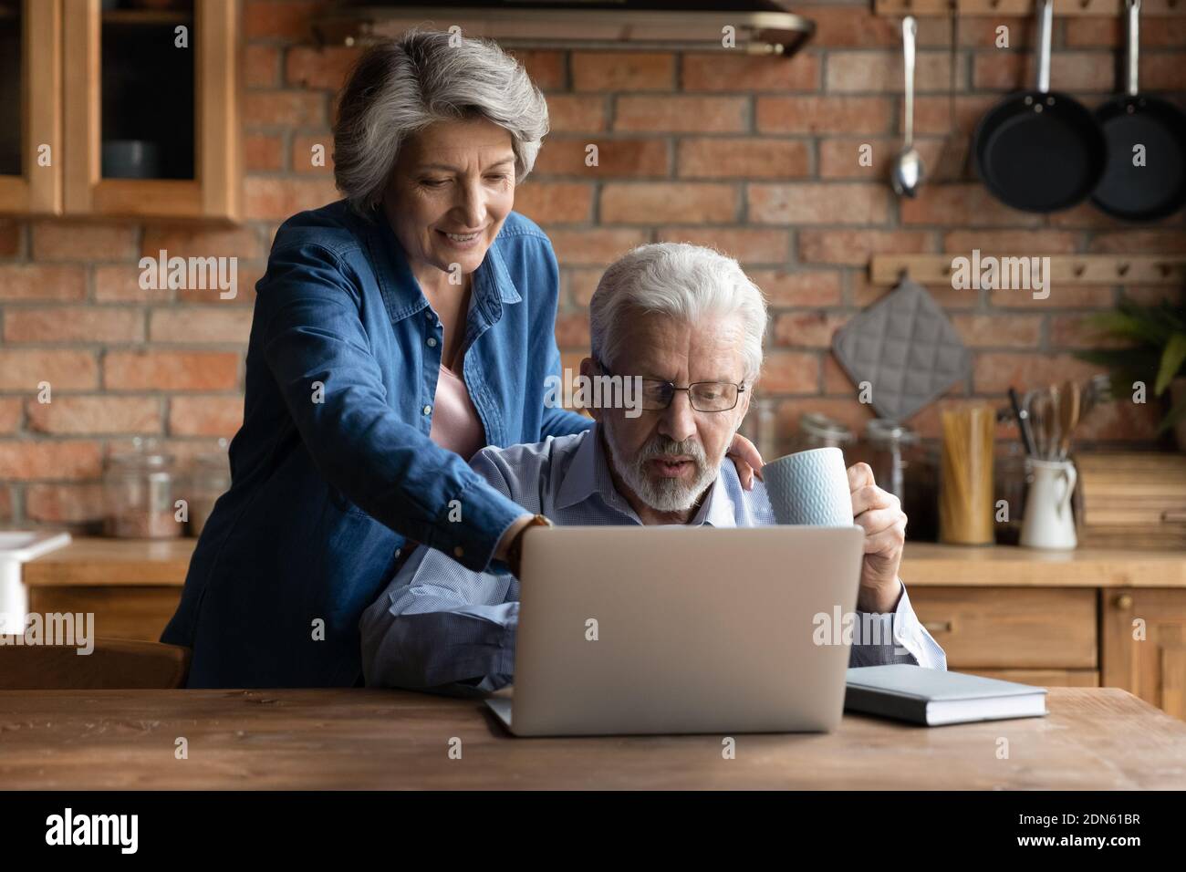 Glückliches Ehepaar mittleren Alters mit Computer. Stockfoto