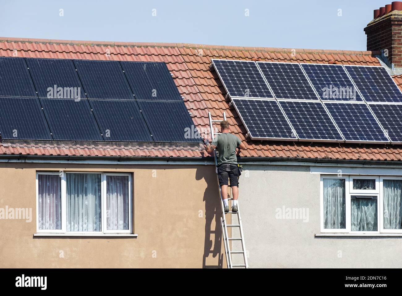 Installation von Photovoltaik-Sonnenkollektoren auf dem Dach von terrassenförmig Haus in London England Vereinigtes Königreich Großbritannien und Nordirland Stockfoto