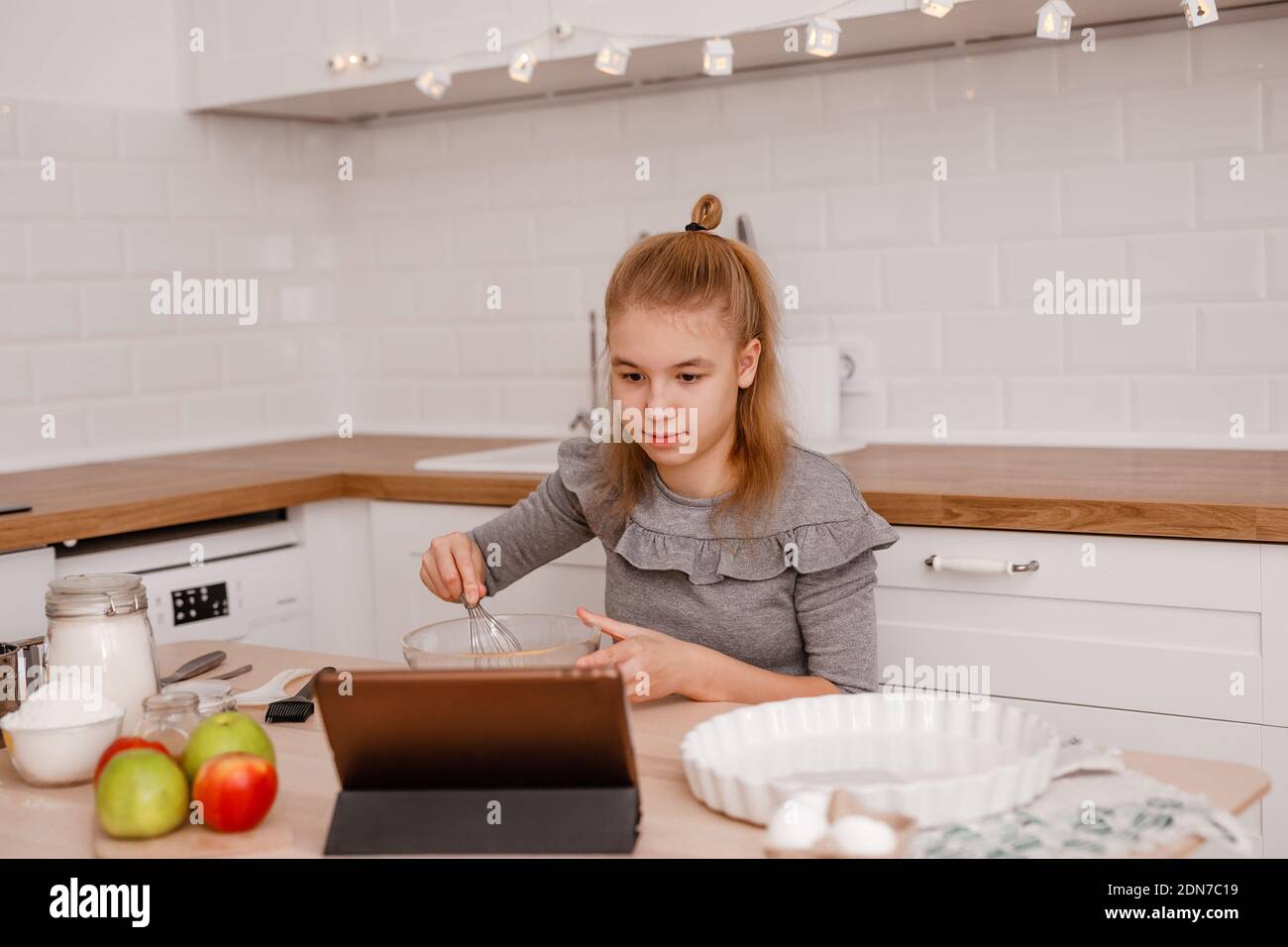 Happy Teenager Mädchen bereitet Apfelkuchen in der Küche Stockfoto