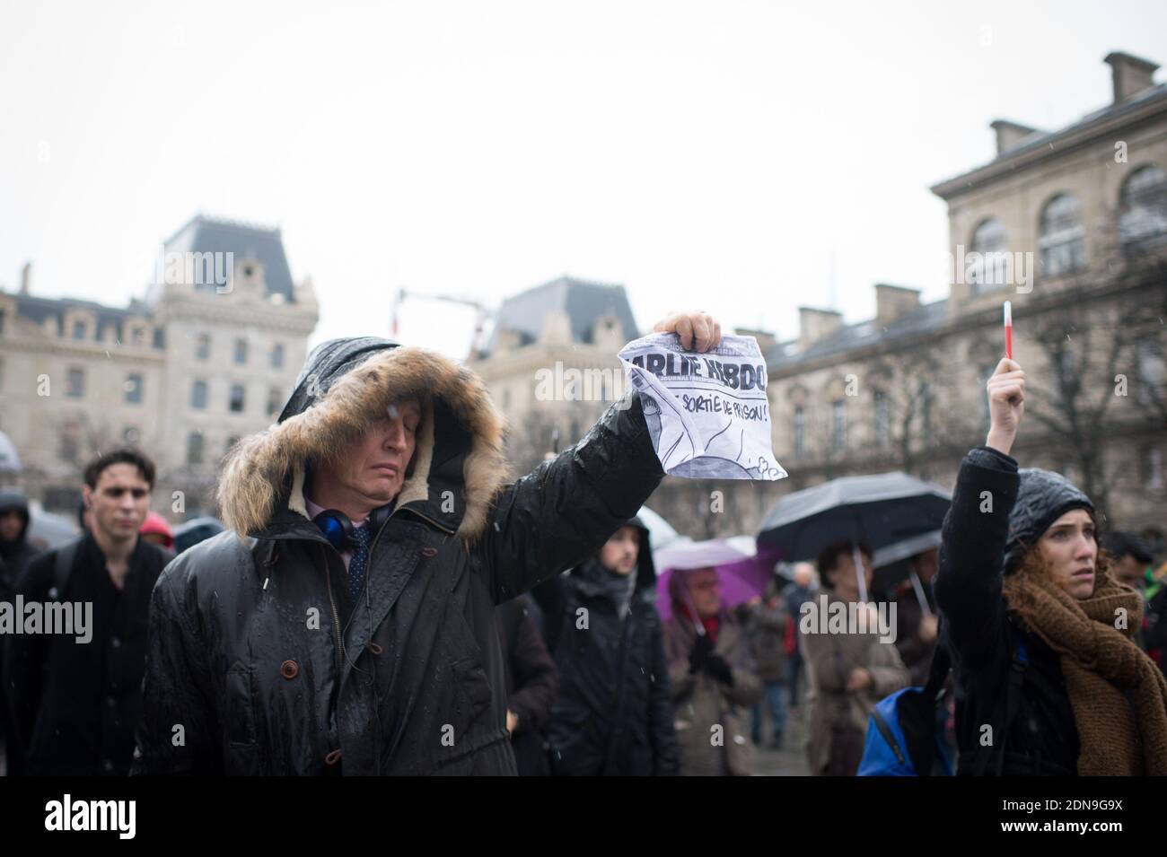 Vor der Kathedrale Notre-Dame de Paris stehen die Menschen unter dem Regen, um am 8. Januar 2015 in Paris, Frankreich, eine Schweigeminute für die Opfer eines Angriffs bewaffneter Schützen in den Büros der französischen Satirezeitung Charlie Hebdo zu halten. Foto von Christophe Guibbaud/ABACPRESS.COM Stockfoto