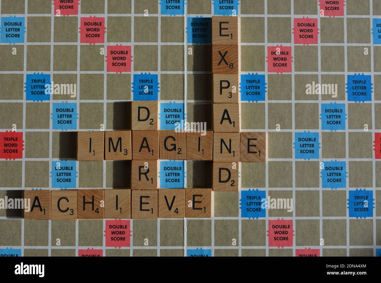 Scrabble Board mit Worten vorstellen, wagen, erweitern, erreichen Stockfoto