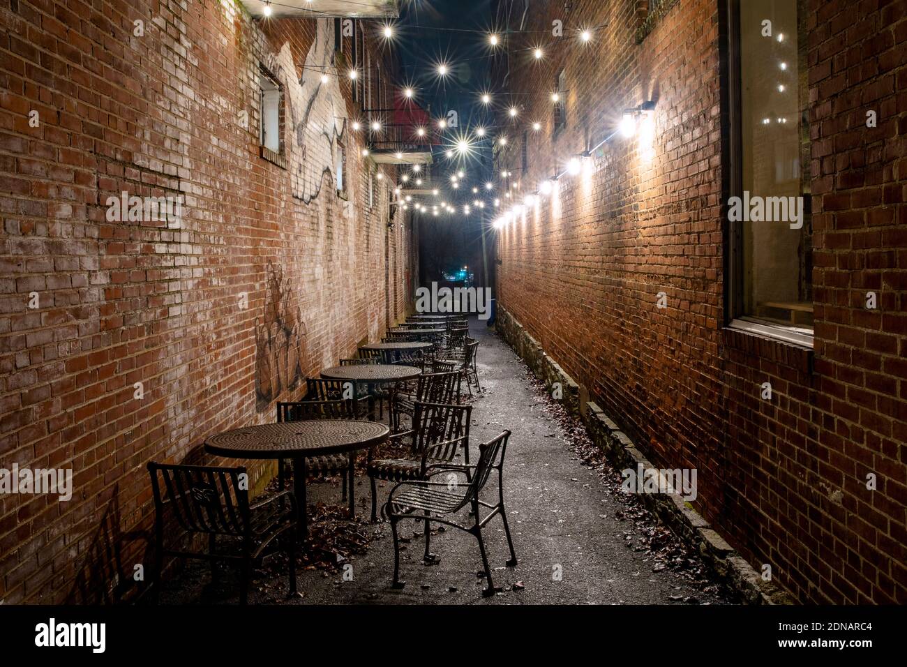 Sitzgelegenheiten im Freien und Feiertagsbeleuchtung in einer Gasse - Downtown Brevard, North Carolina, USA Stockfoto